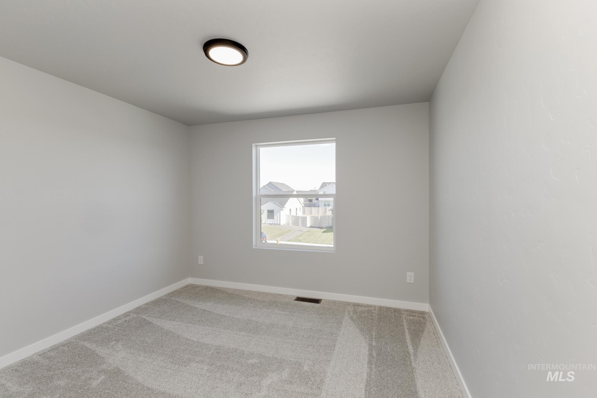 Empty room with carpet and baseboards