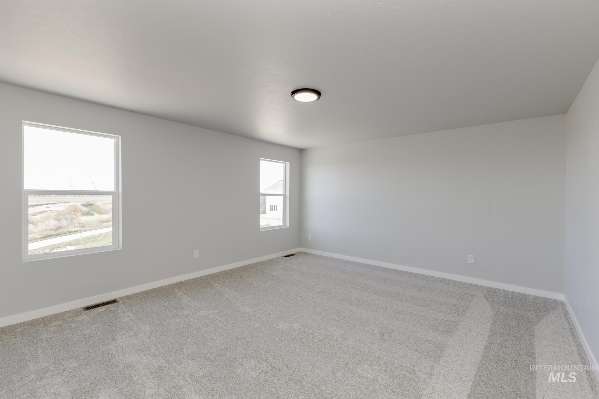 Empty room featuring light carpet