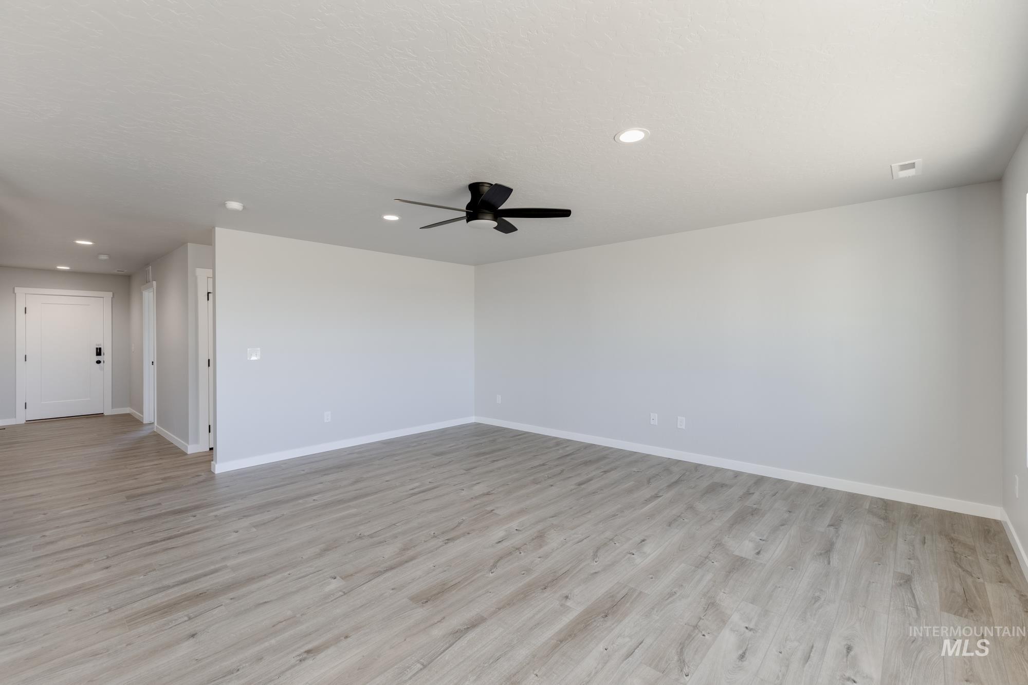 Empty room featuring light wood-style floors, recessed lighting, and ceiling fan