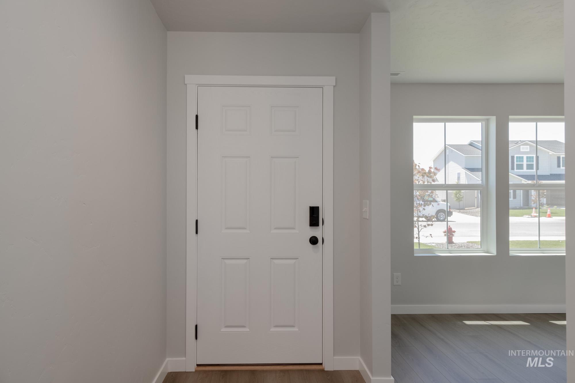 Entryway featuring baseboards and dark wood-type flooring