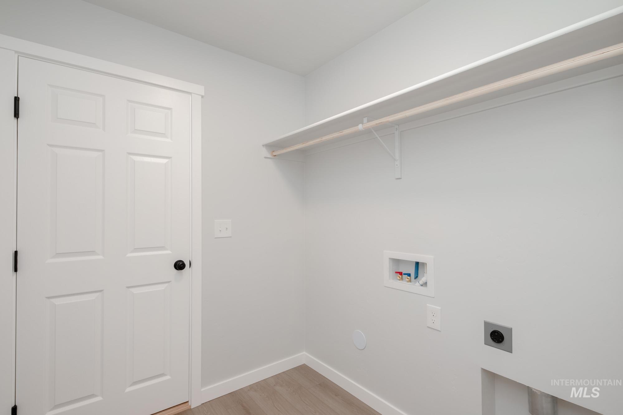 Laundry area featuring hookup for an electric dryer, light wood-style floors, and hookup for a washing machine