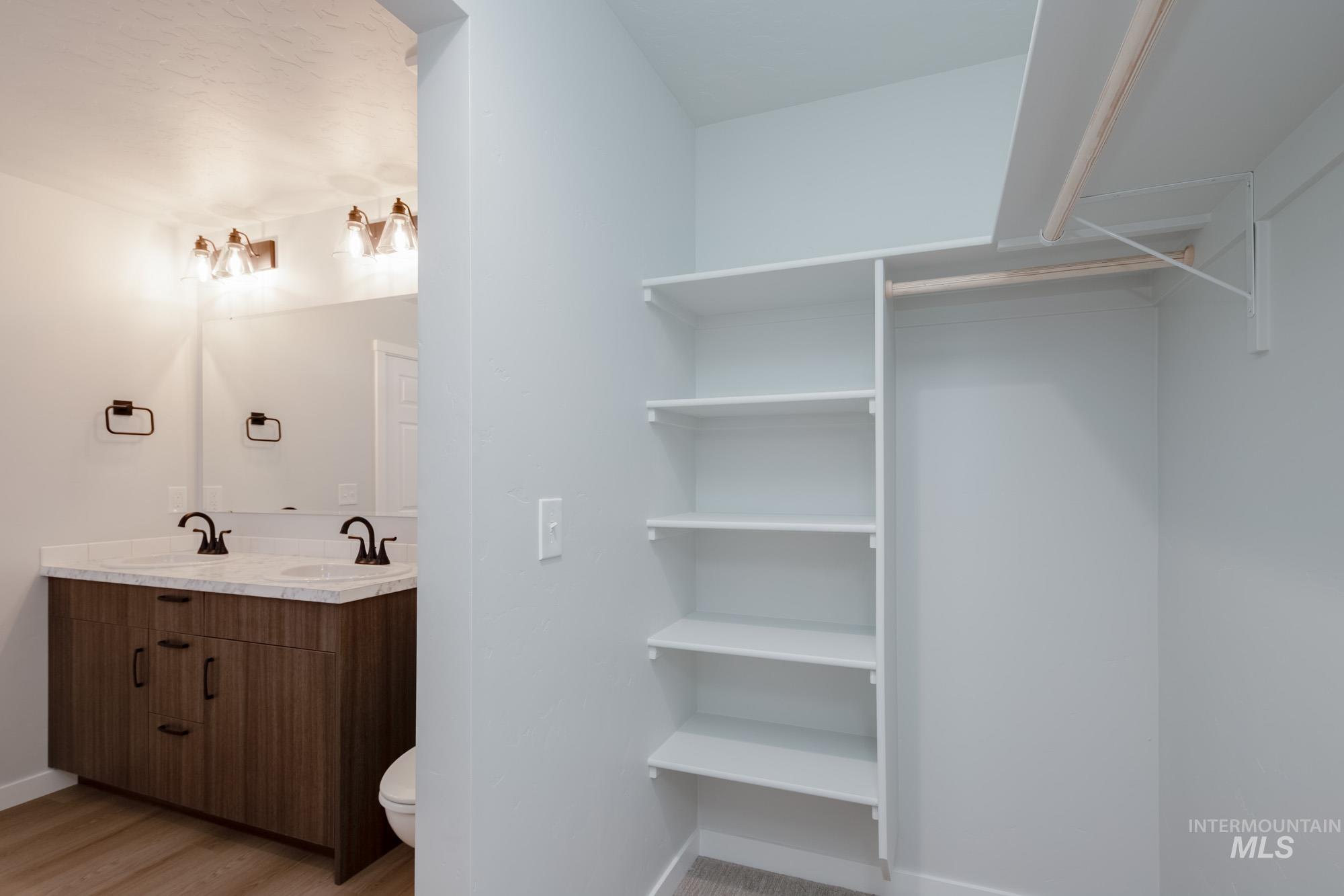 Spacious closet with light wood-style floors and a sink