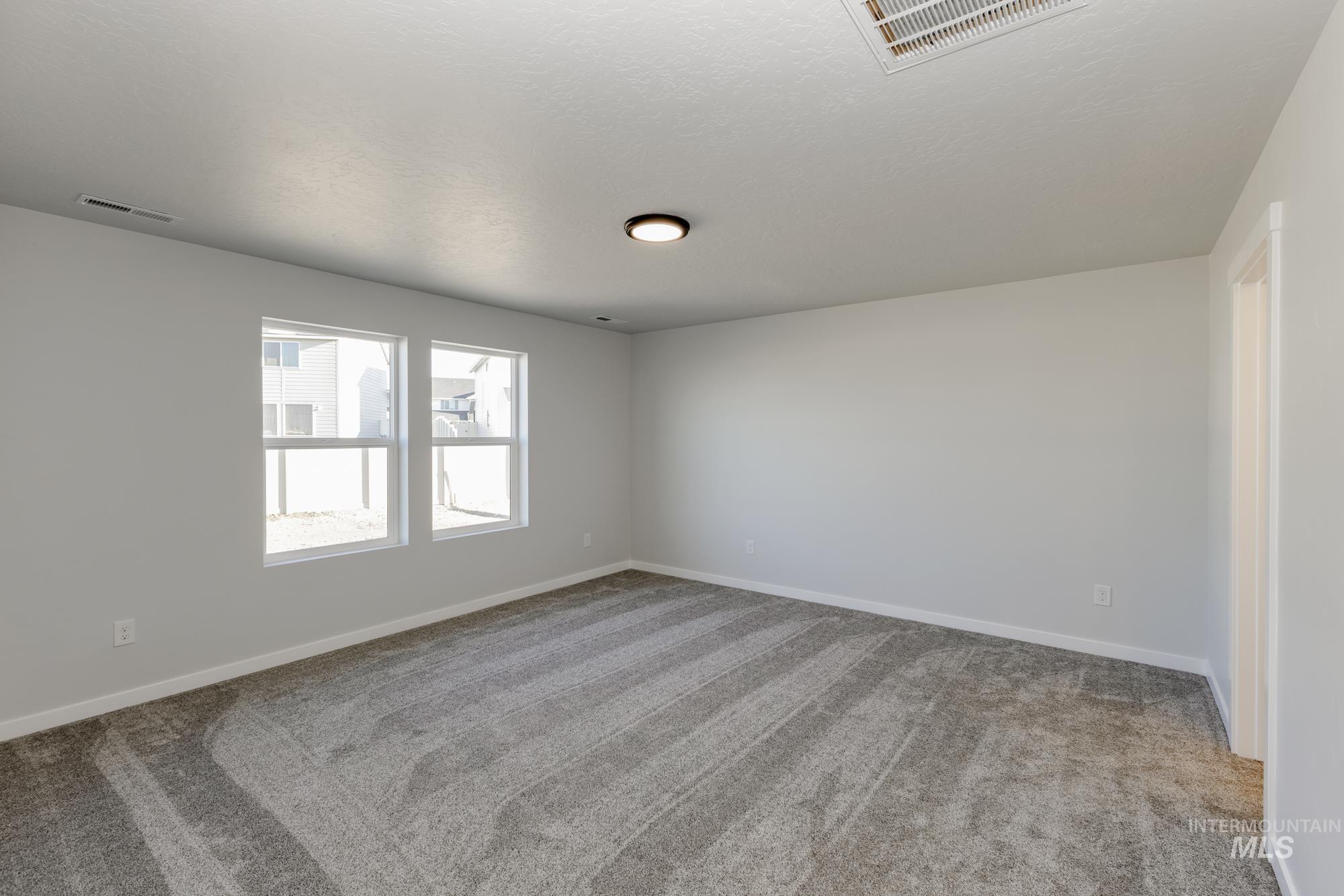 Empty room featuring light carpet and baseboards