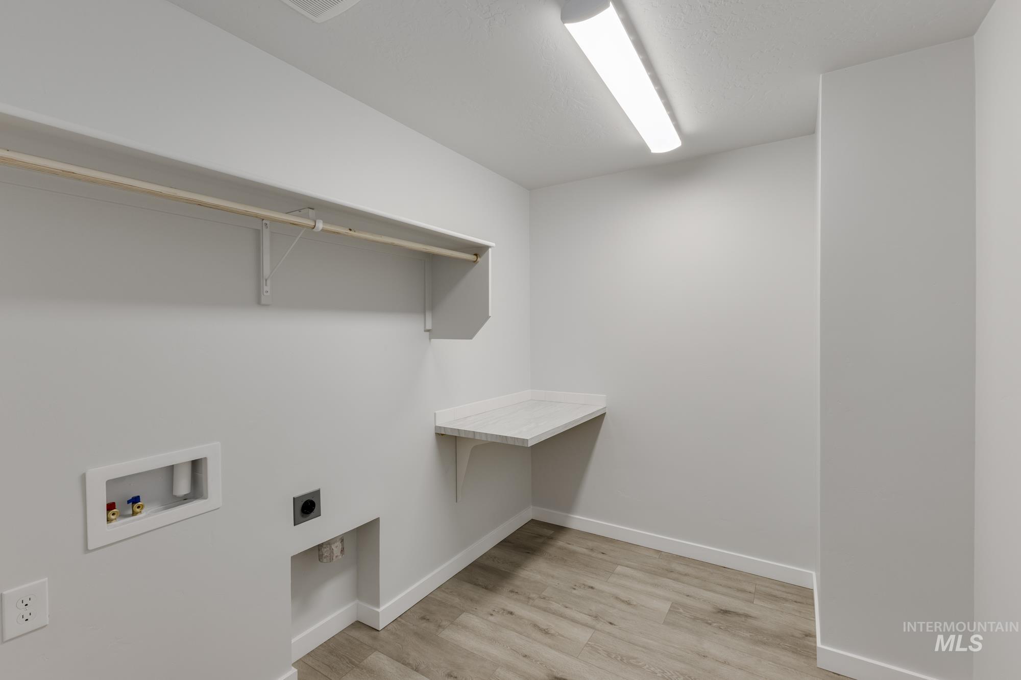 Laundry room with light wood-style floors, electric dryer hookup, and hookup for a washing machine