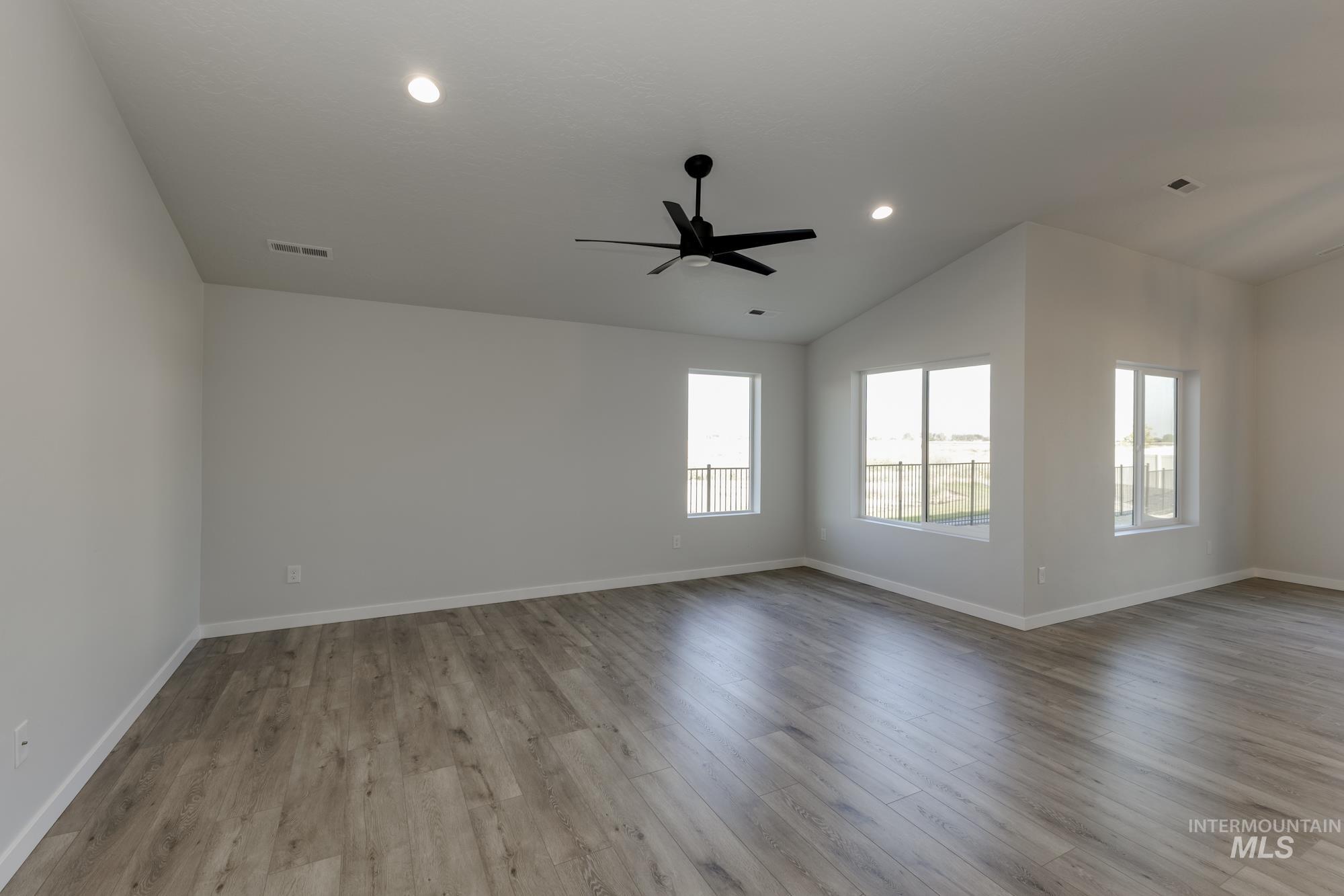 Spare room with vaulted ceiling, light wood-style flooring, ceiling fan, and recessed lighting