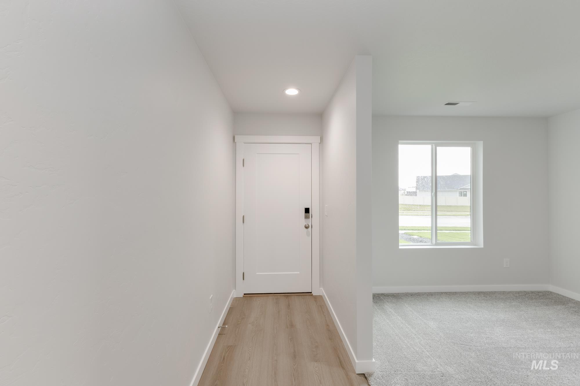 Foyer entrance with light wood-style floors and recessed lighting