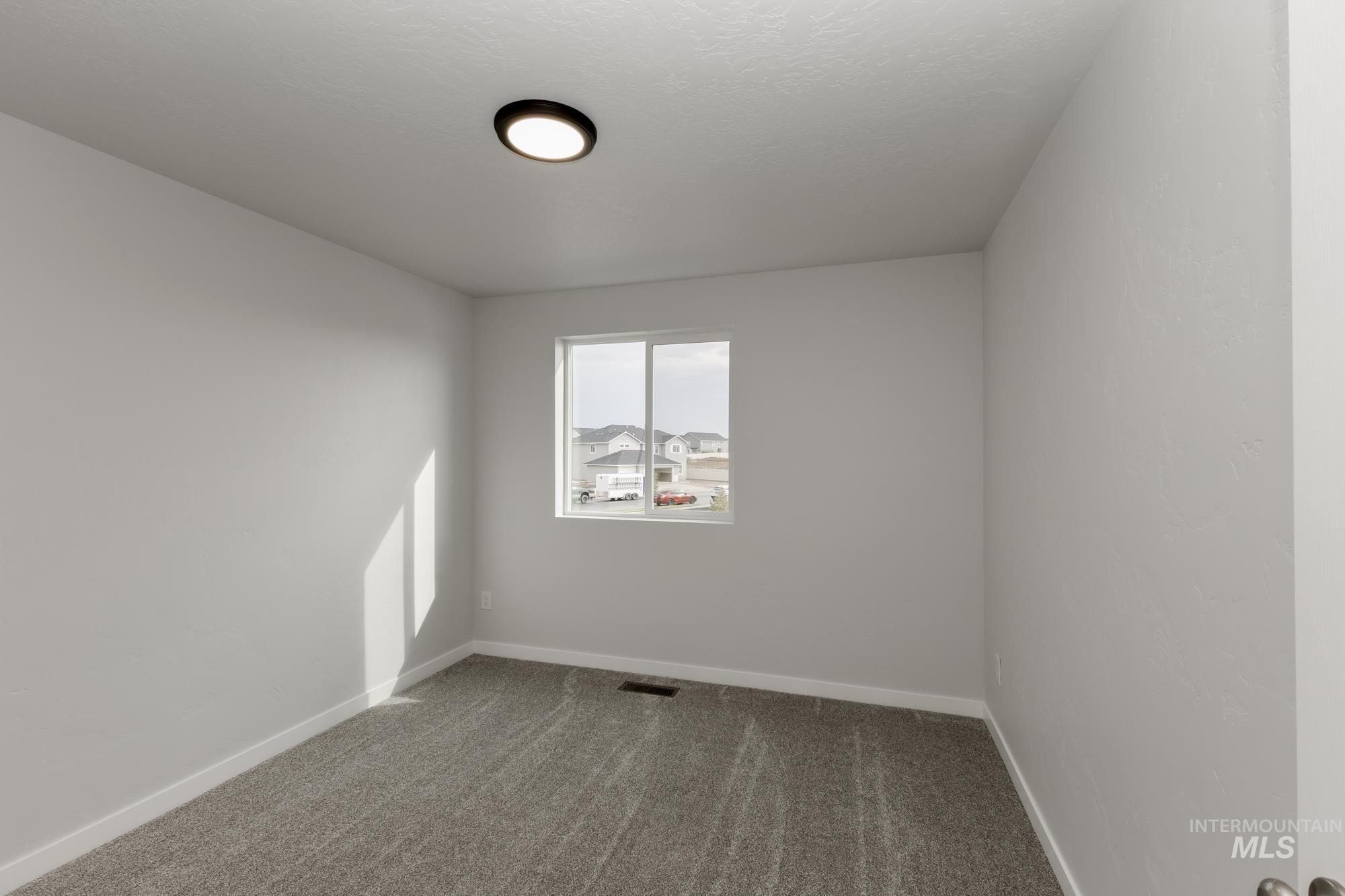Carpeted empty room with baseboards
