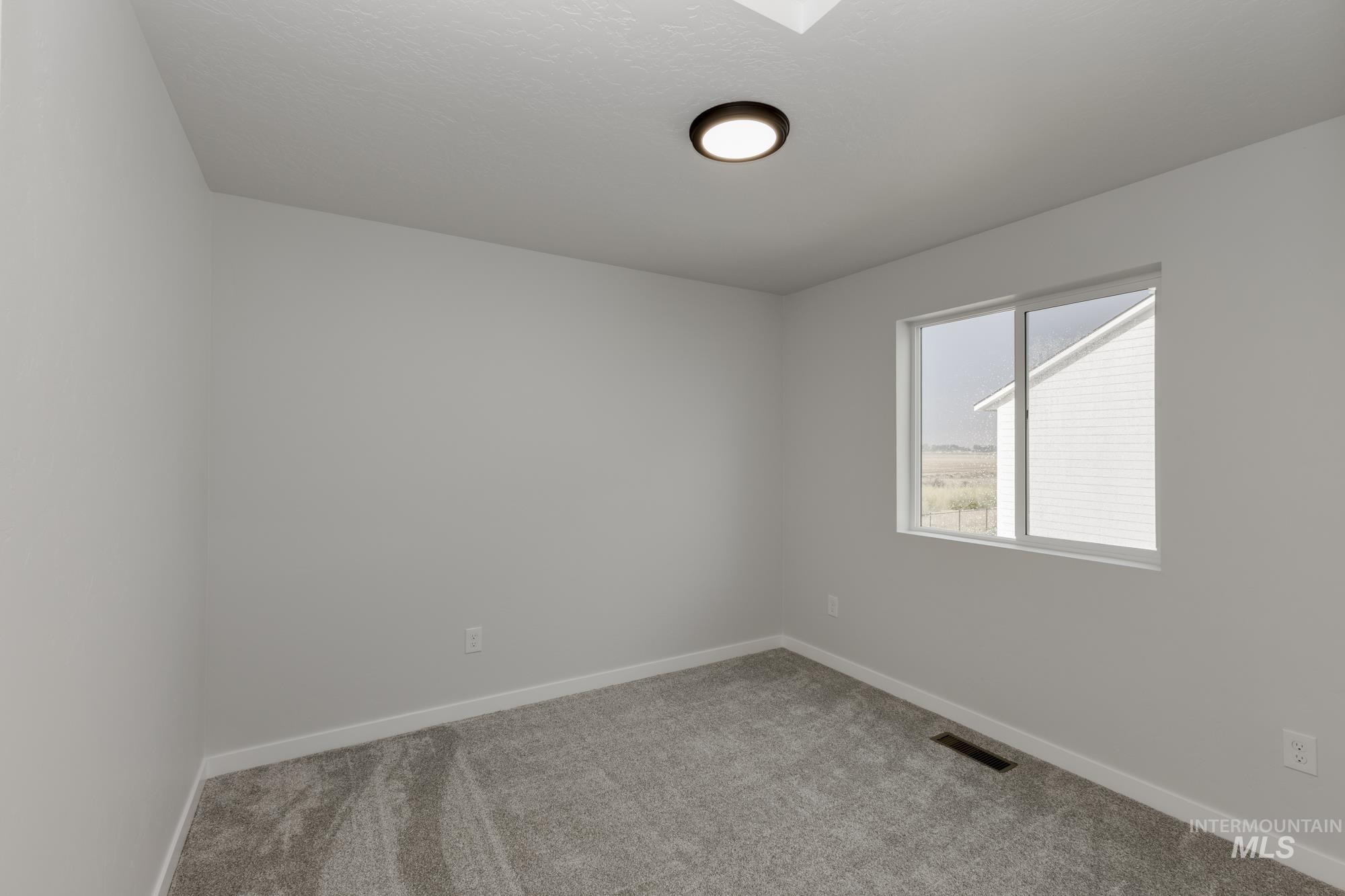 Carpeted spare room with baseboards