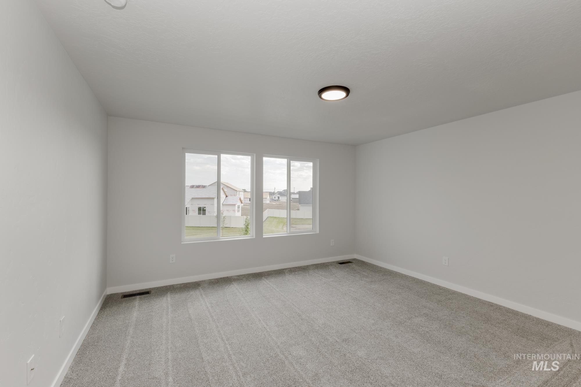 Unfurnished room with light colored carpet and baseboards