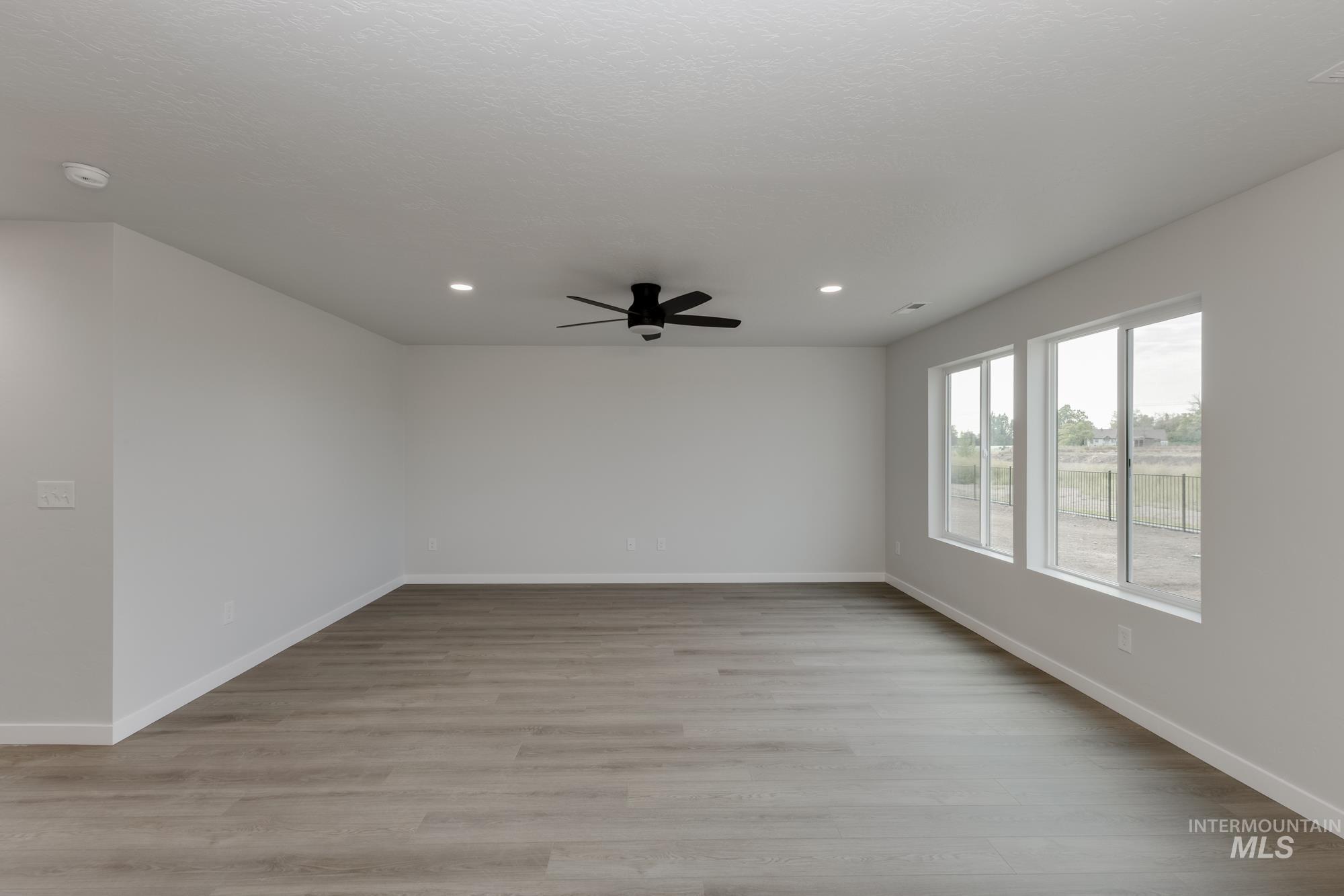 Empty room with light wood-style floors, recessed lighting, and a ceiling fan