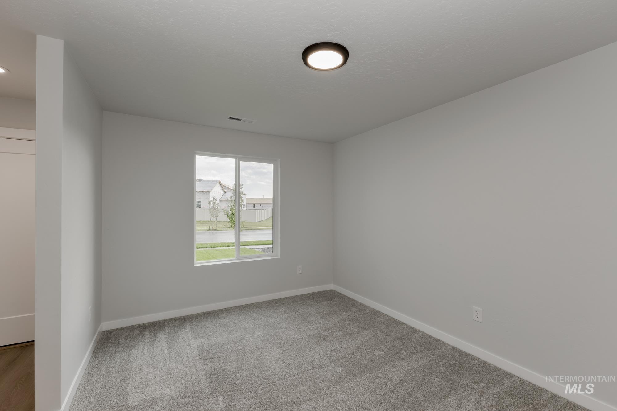 Unfurnished room with light colored carpet and baseboards