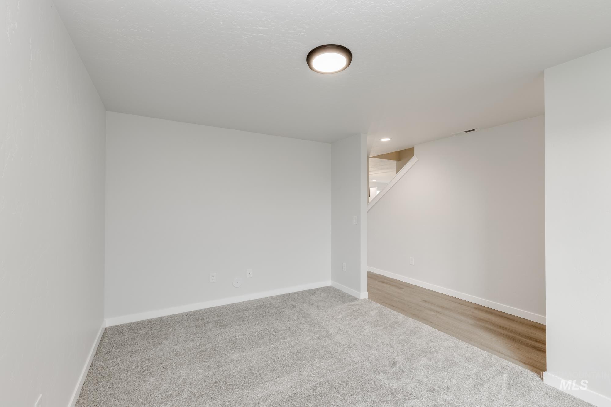 Basement featuring light carpet and baseboards