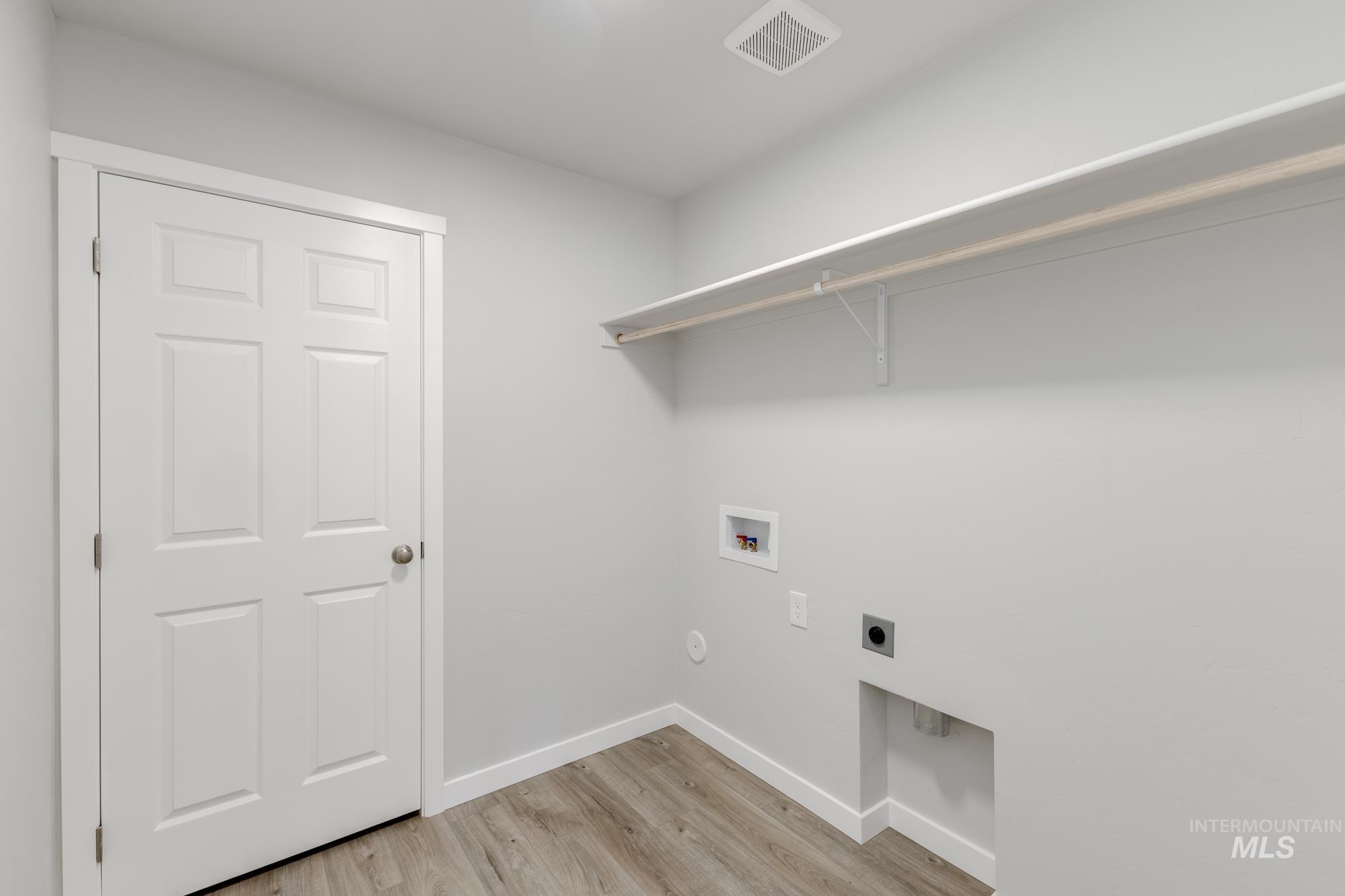 Washroom with light wood-style floors, electric dryer hookup, and hookup for a washing machine