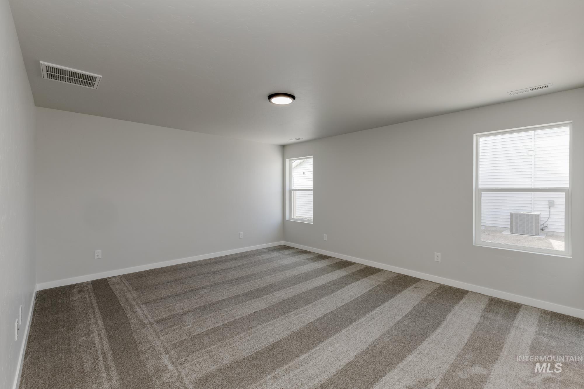 Spare room featuring light carpet and baseboards
