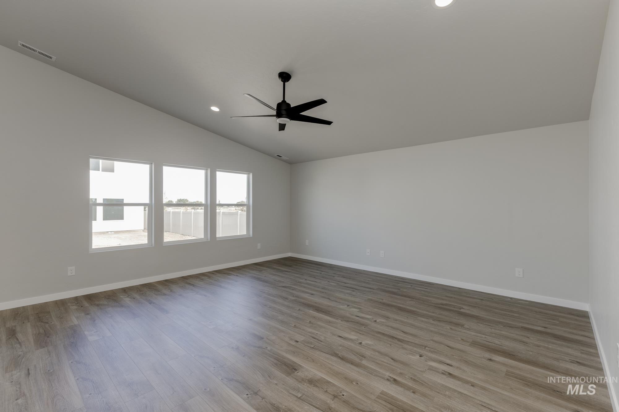 Spare room with light wood-style flooring, vaulted ceiling, recessed lighting, and a ceiling fan