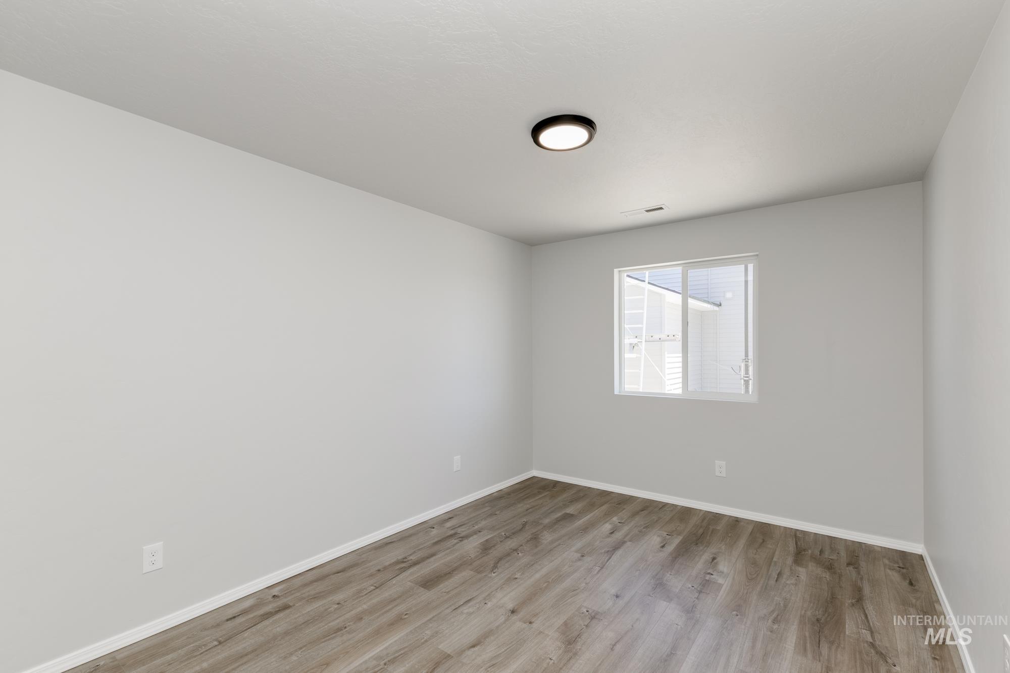 Empty room featuring light wood finished floors and baseboards