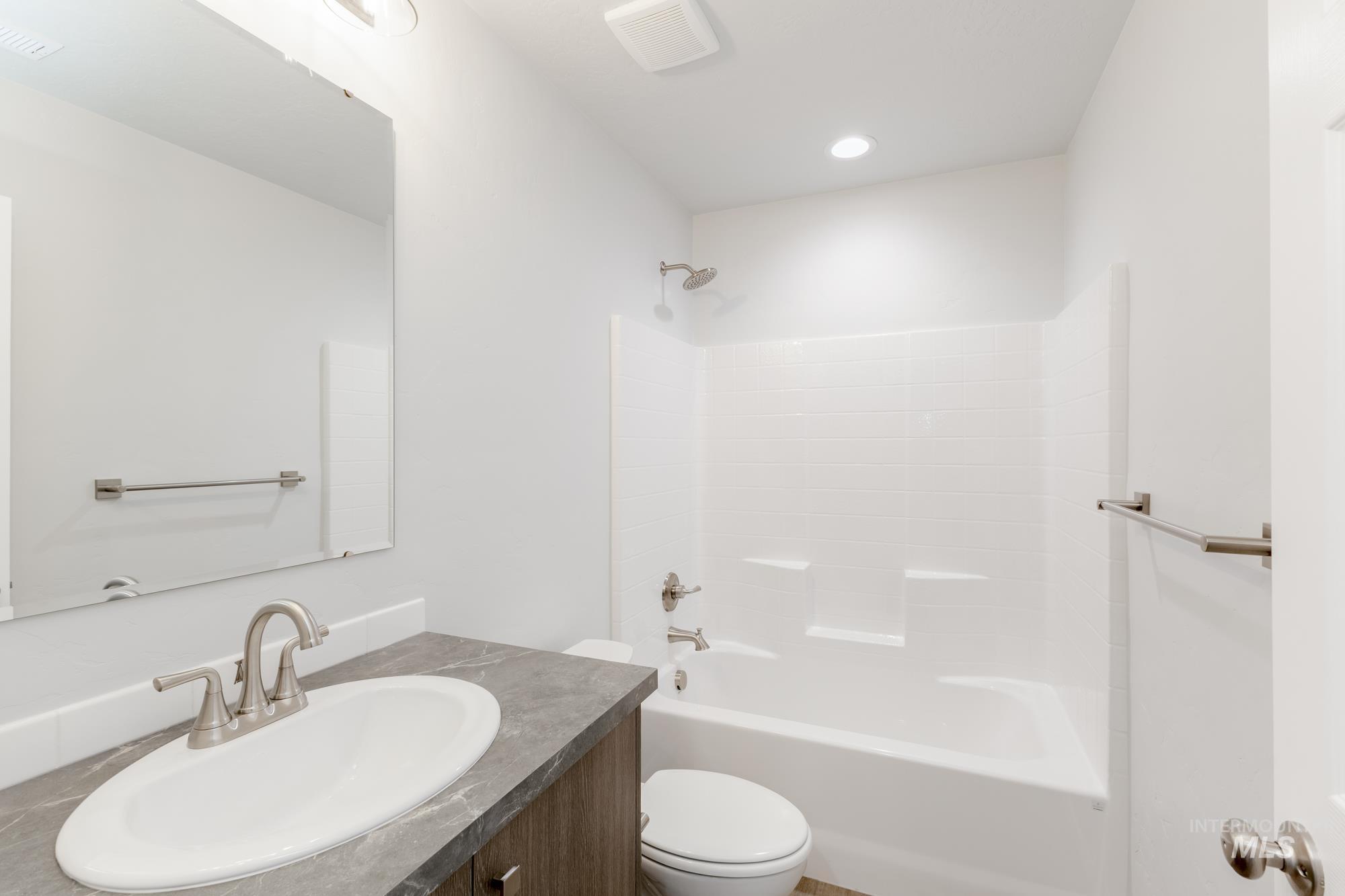 Bathroom featuring shower / tub combination, vanity, and recessed lighting