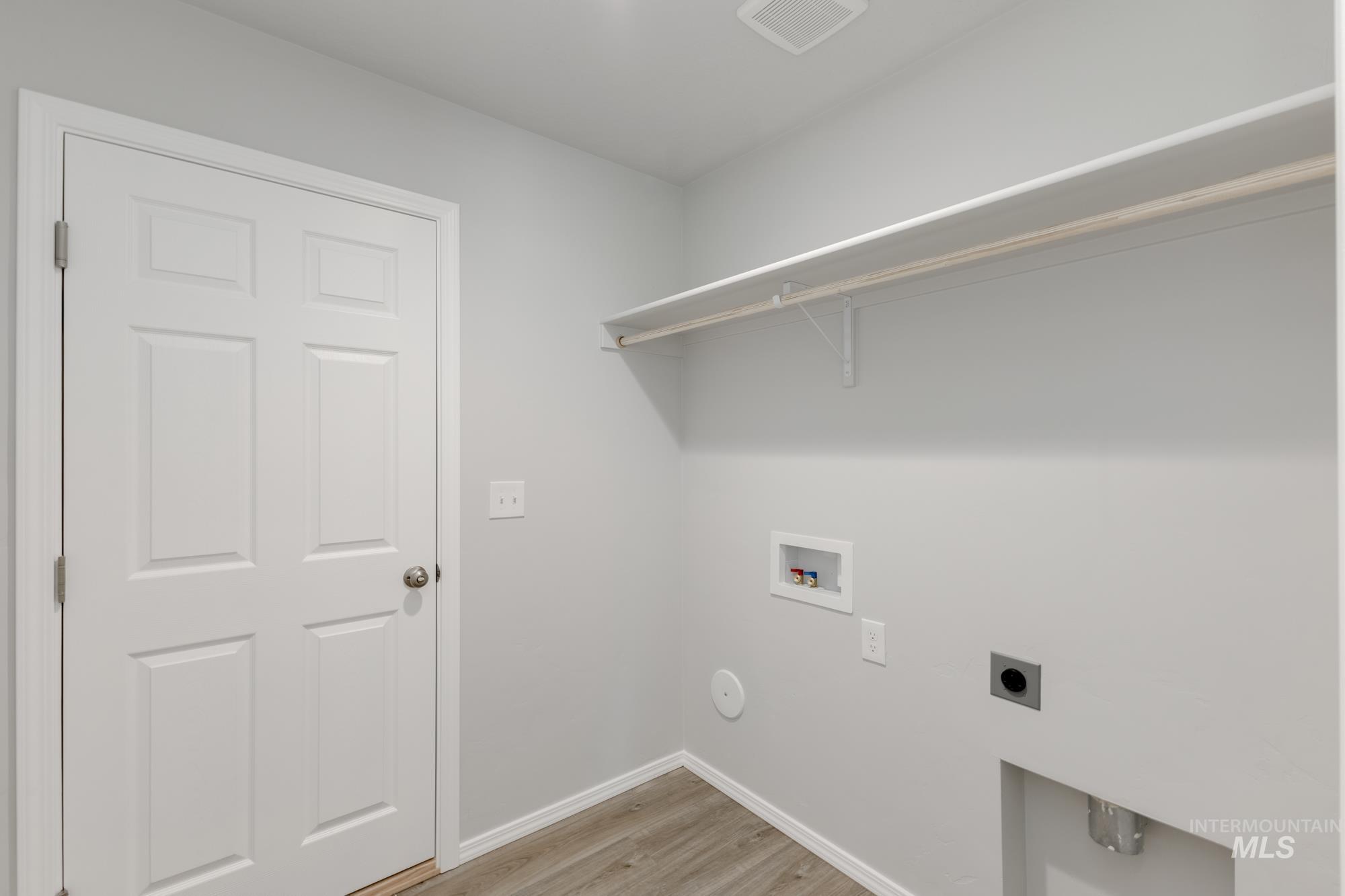 Laundry room with light wood-style flooring, electric dryer hookup, and hookup for a washing machine