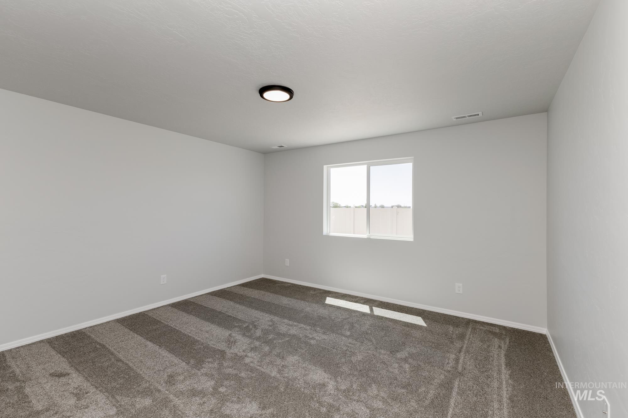 Empty room with dark carpet and baseboards