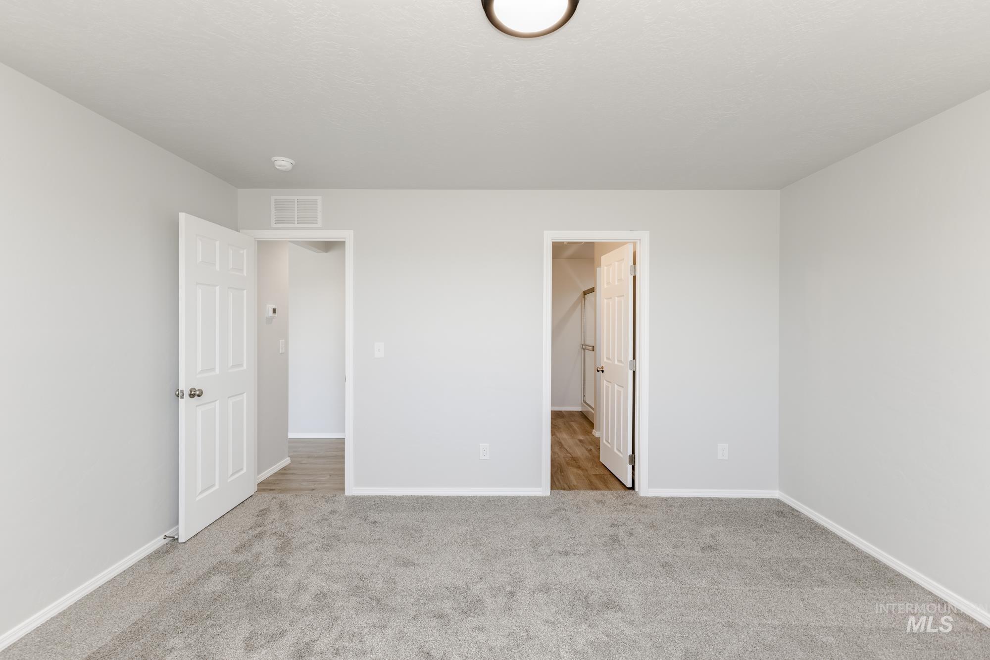 Unfurnished bedroom with light carpet