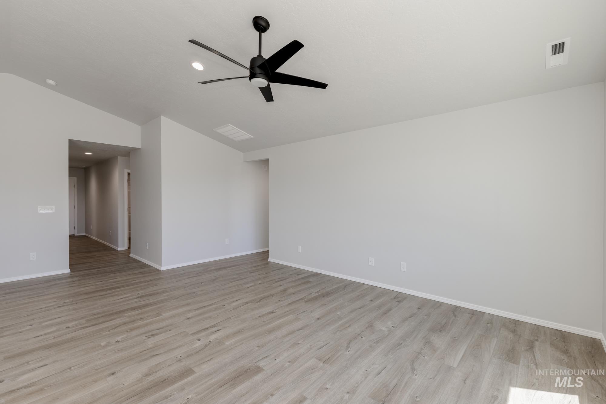Unfurnished room featuring light wood-style floors, vaulted ceiling, recessed lighting, and a ceiling fan