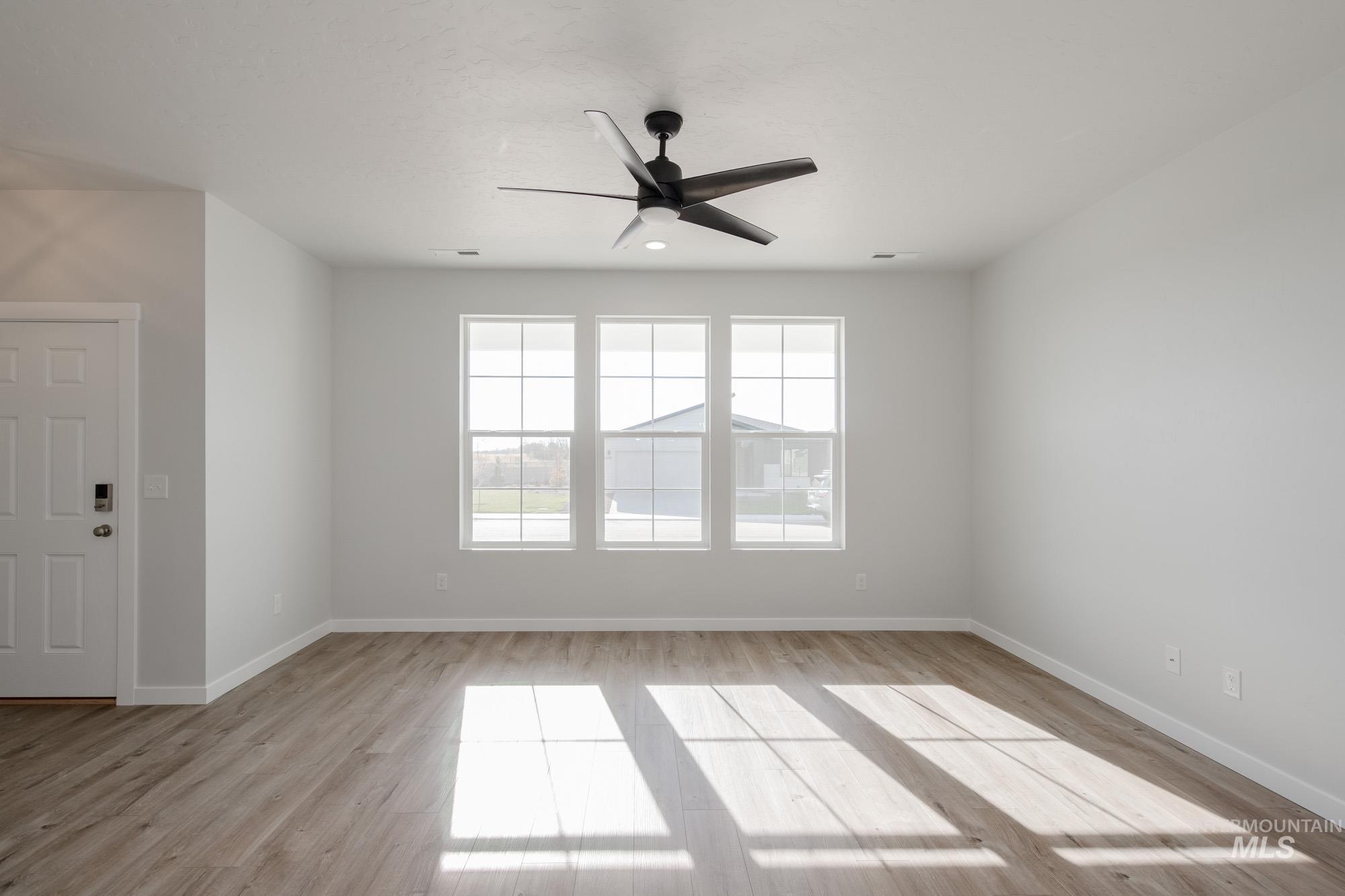 Spare room with a ceiling fan and light wood-type flooring