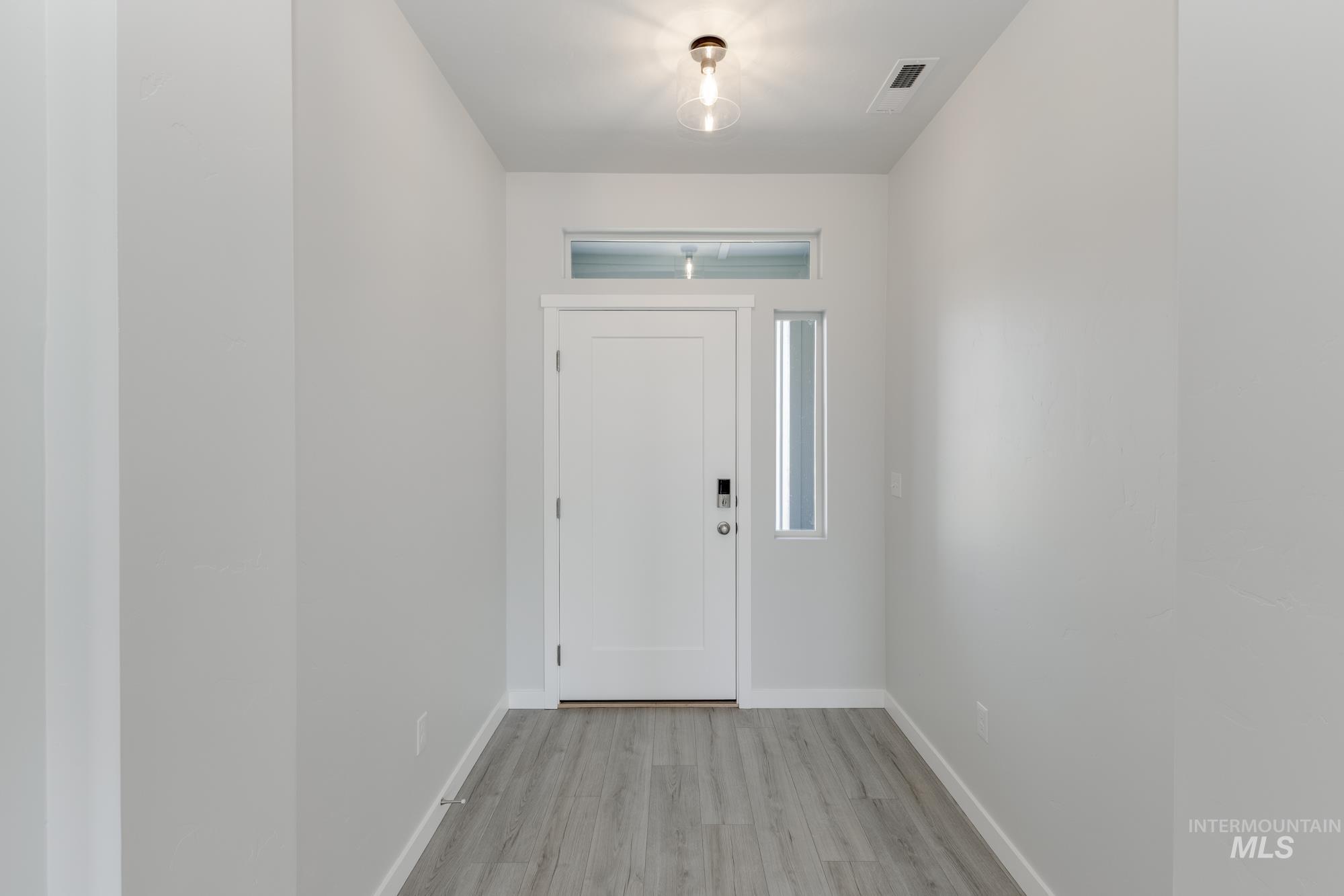 Entryway featuring baseboards and light wood finished floors