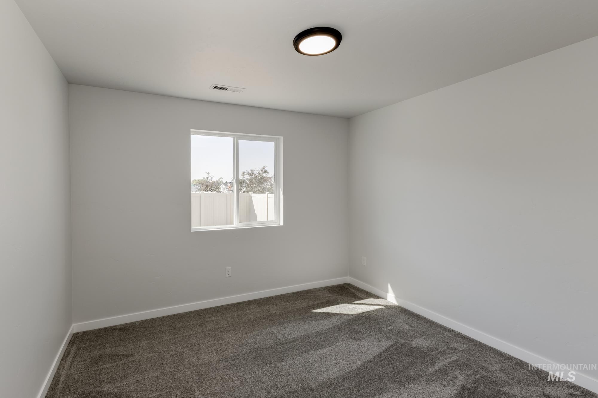 Unfurnished room with dark carpet and baseboards