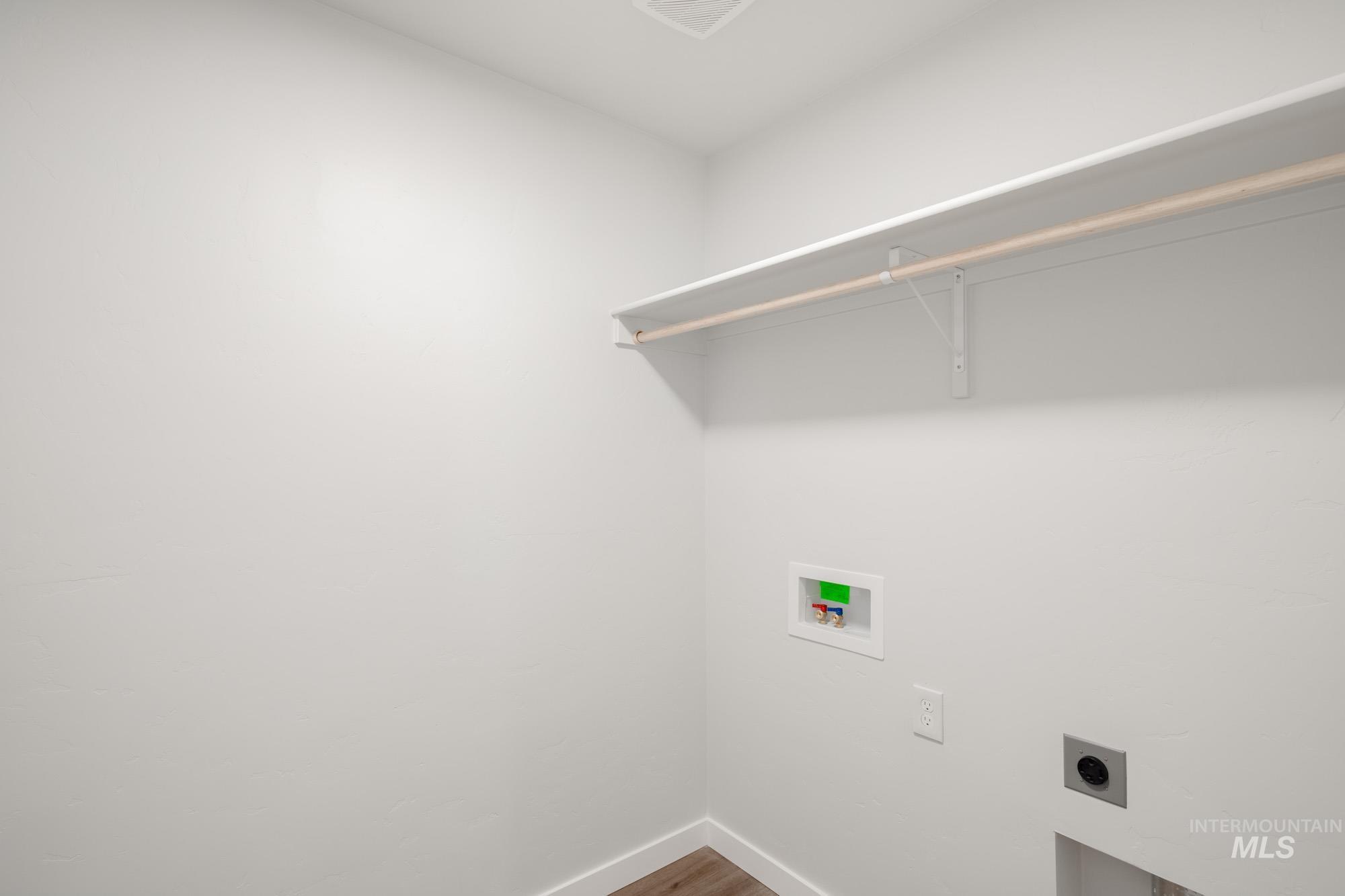 Laundry room featuring hookup for an electric dryer, hookup for a washing machine, and wood finished floors