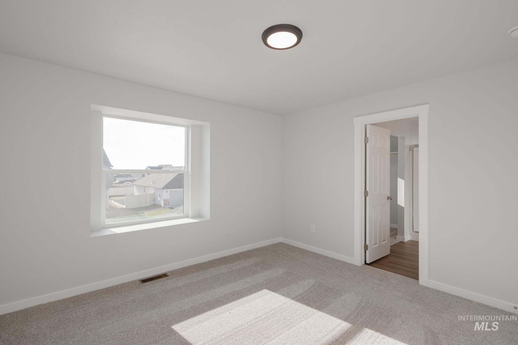 Unfurnished bedroom with carpet flooring and baseboards