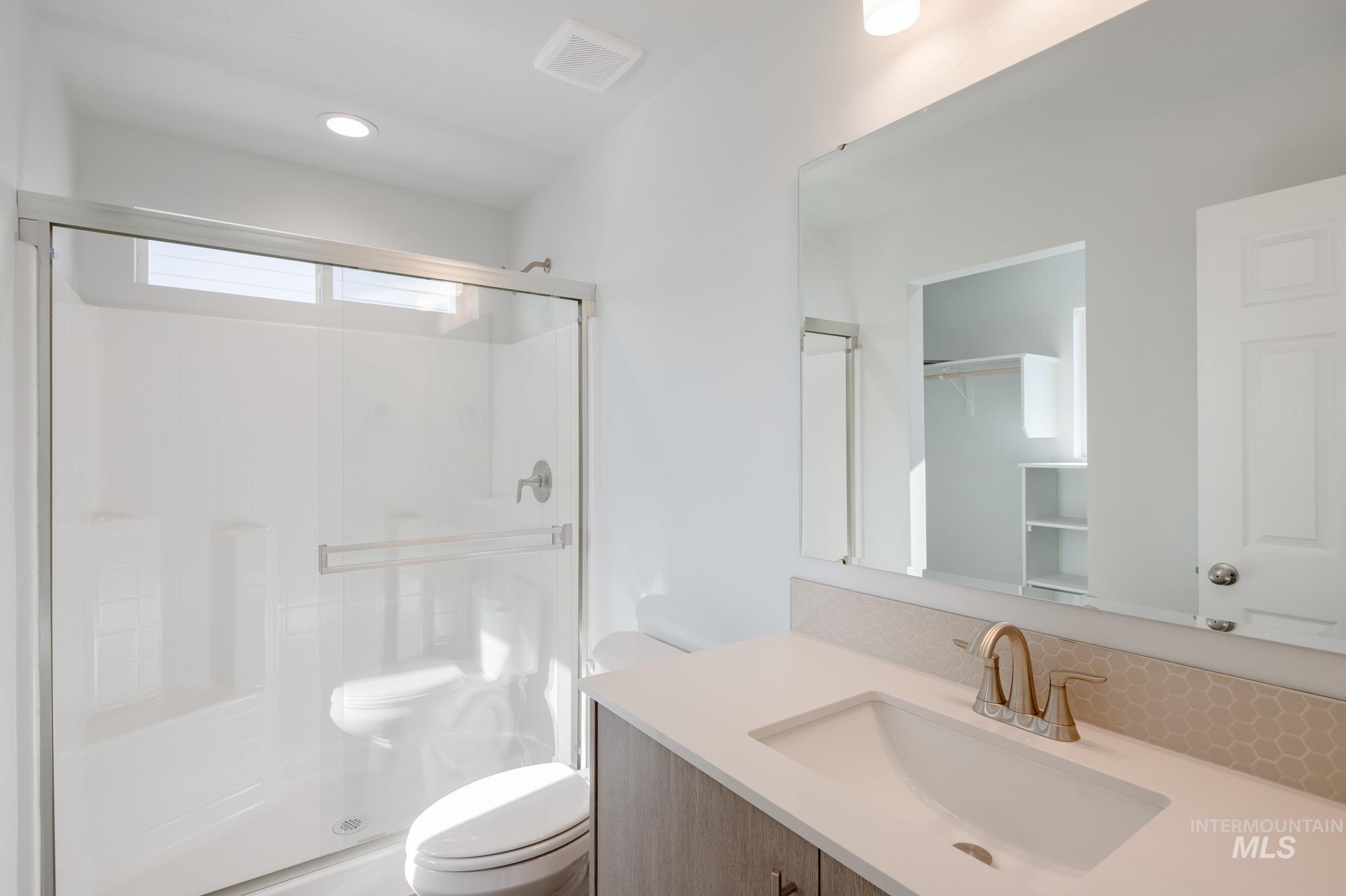 Bathroom with vanity, a stall shower, and recessed lighting