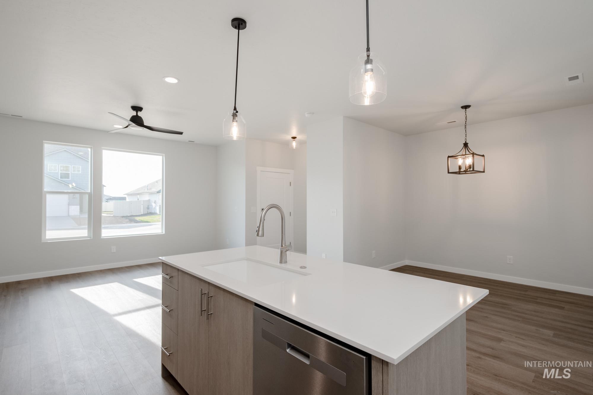 Kitchen with open floor plan, dishwasher, light wood finished floors, hanging light fixtures, and recessed lighting