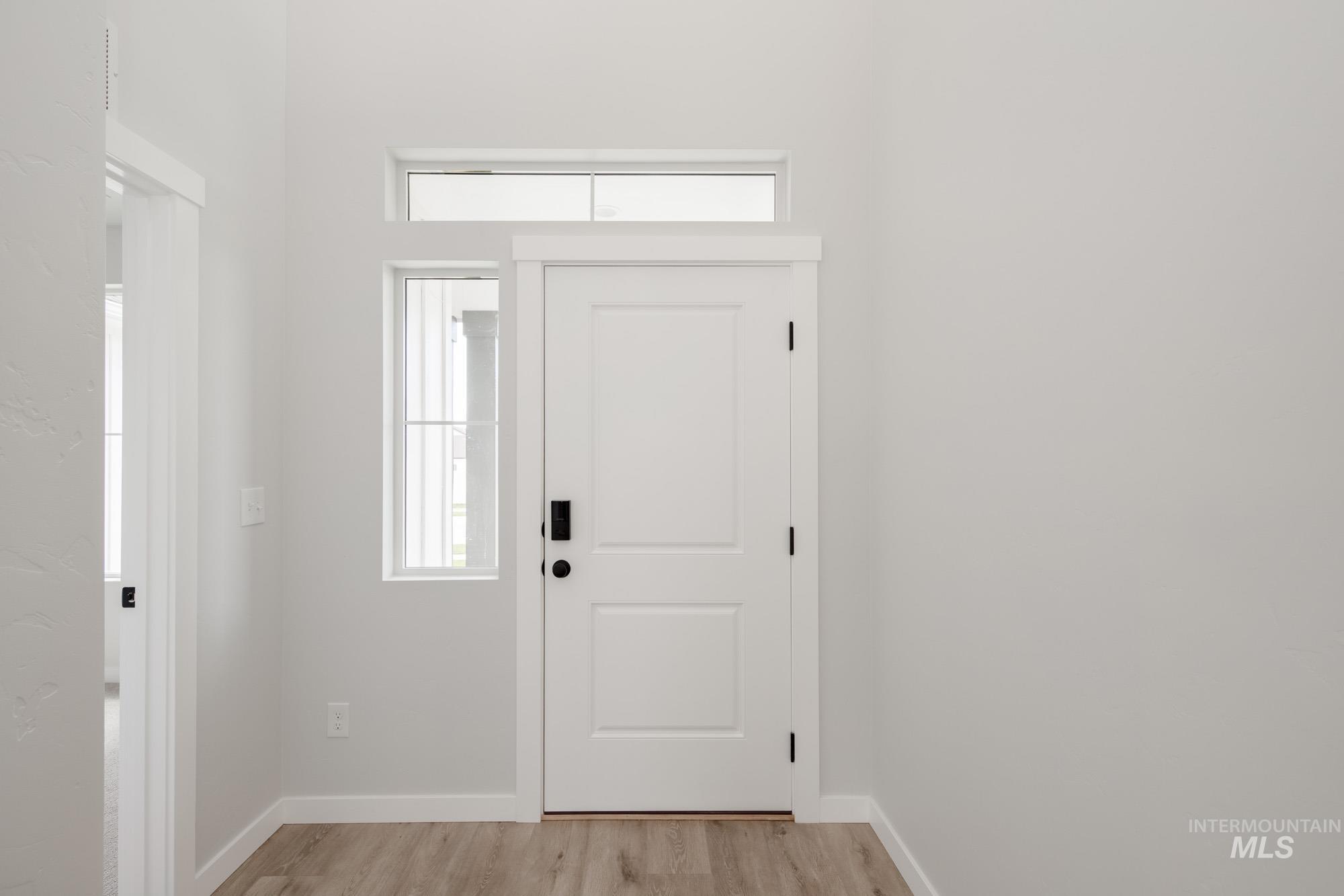 Entryway with light wood-style floors and baseboards