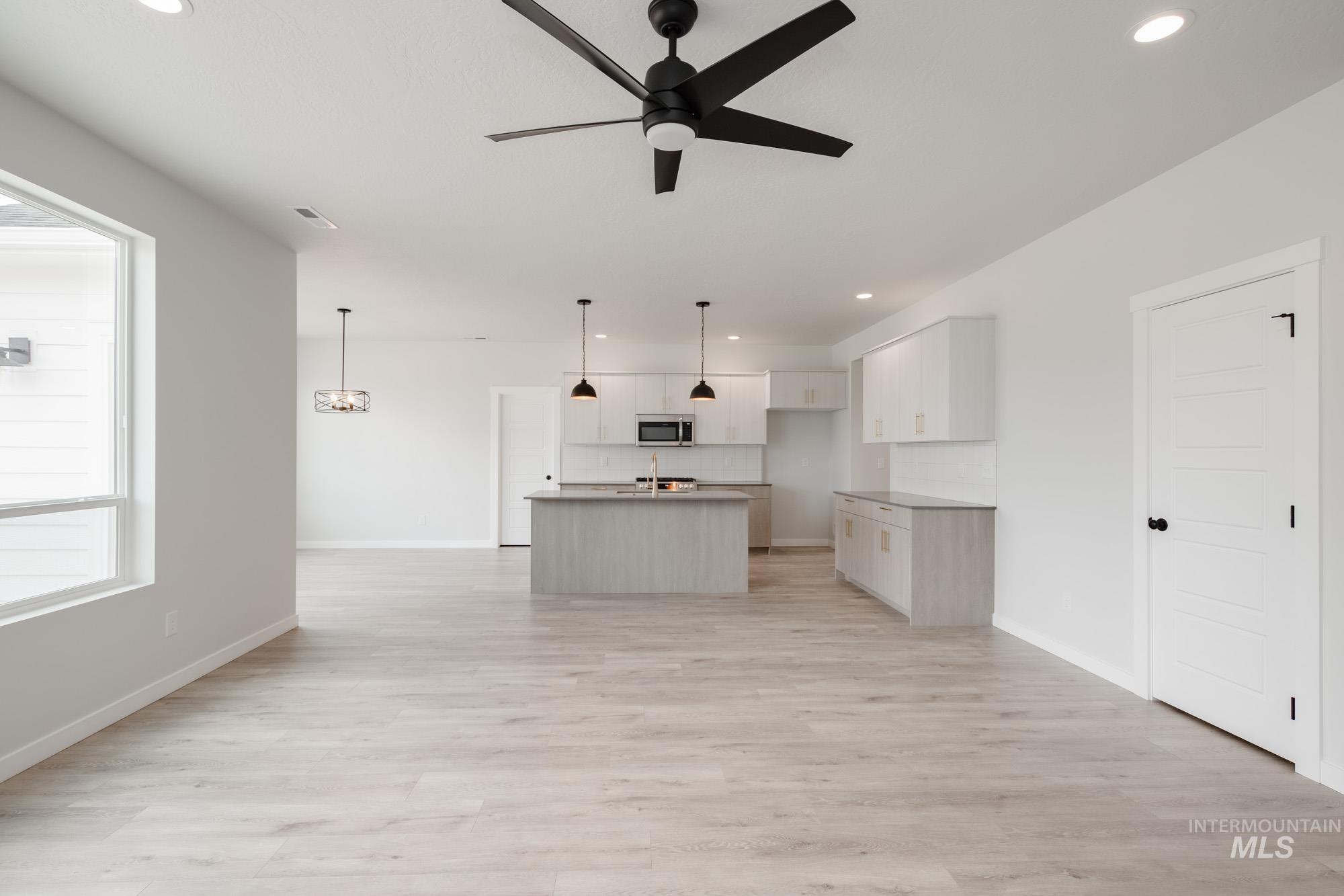 Unfurnished living room with recessed lighting, light wood-type flooring, and ceiling fan