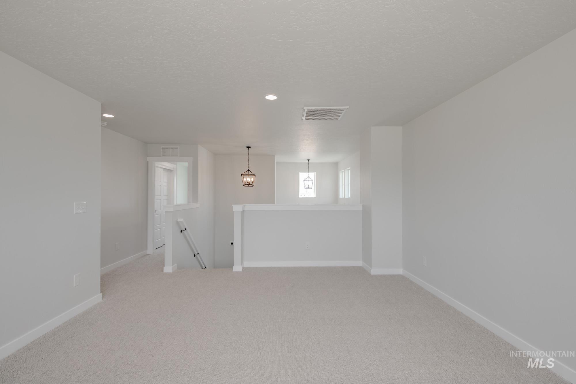 Empty room featuring light colored carpet and recessed lighting