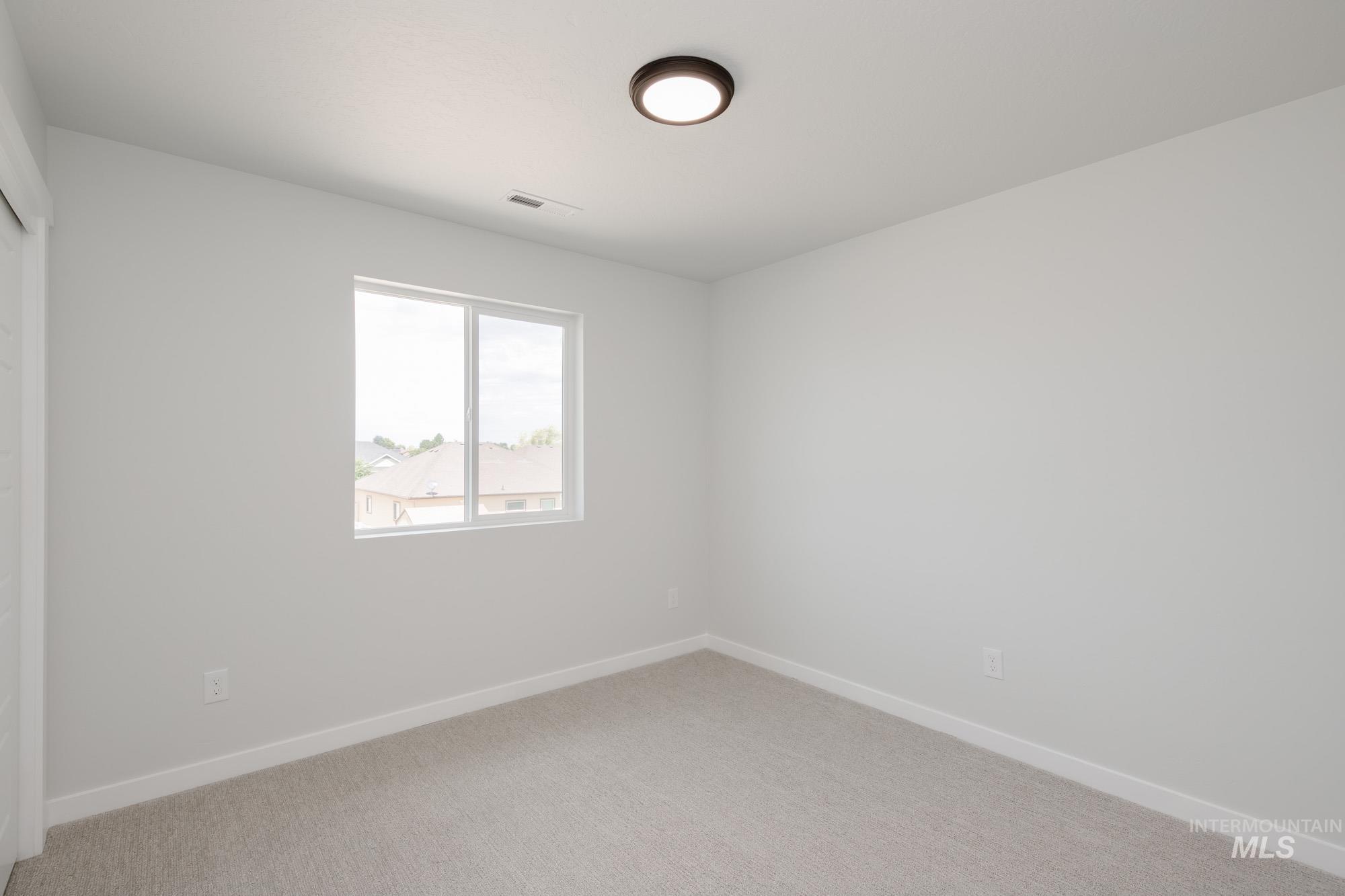 Spare room featuring baseboards and light carpet