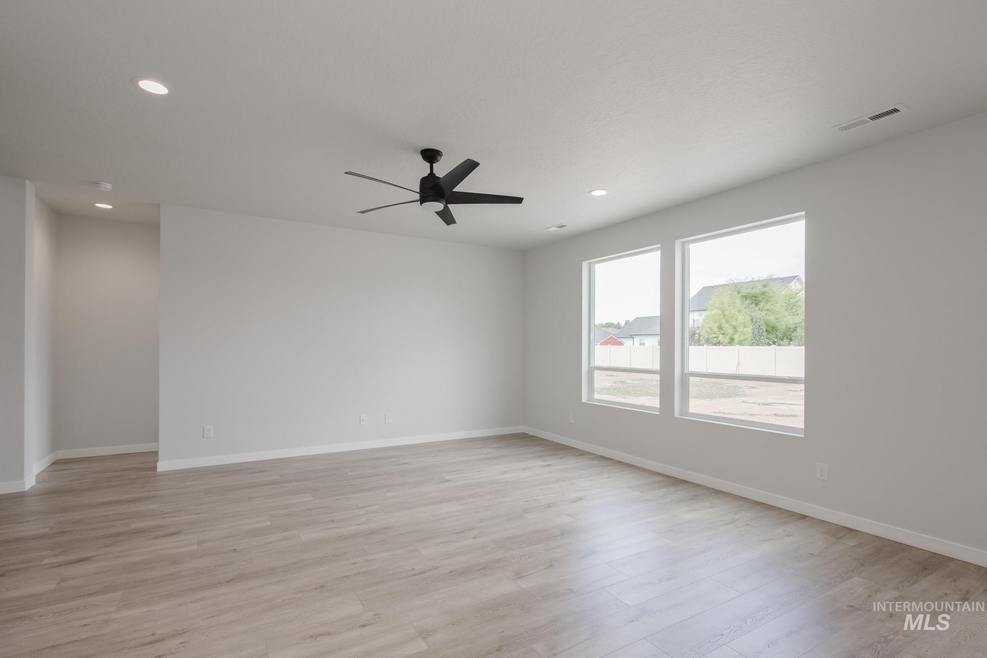 Empty room with light wood-type flooring, recessed lighting, and a ceiling fan