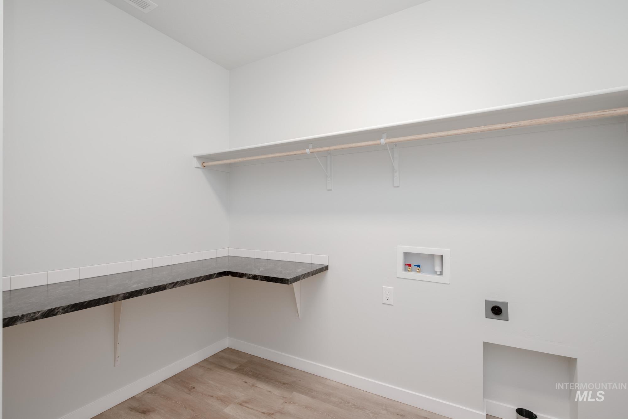 Laundry room with light wood-style flooring, washer hookup, and electric dryer hookup