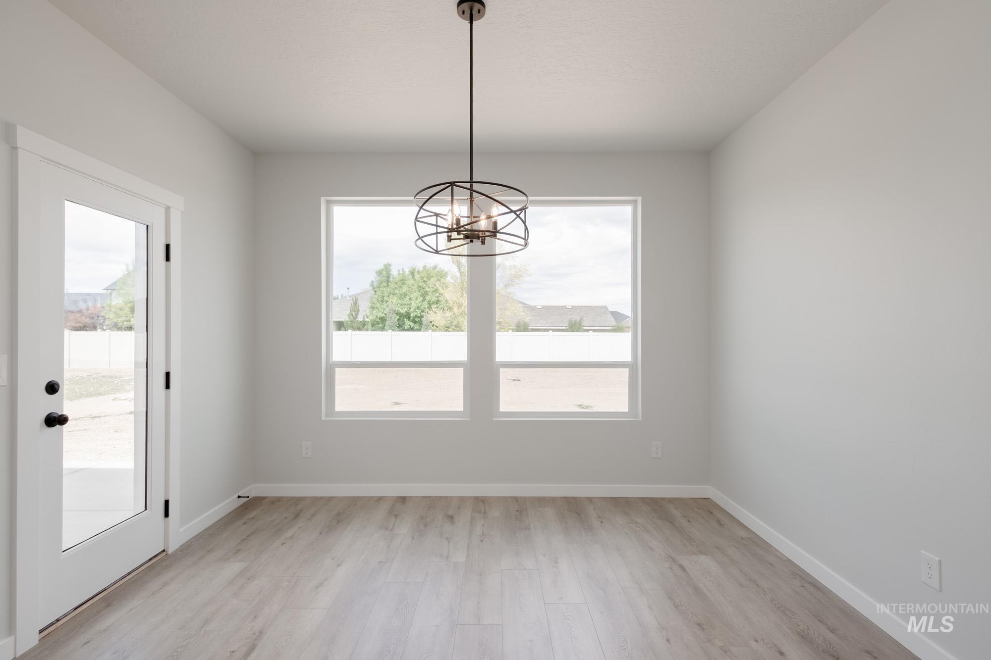 Unfurnished dining area with light wood-style flooring and a chandelier