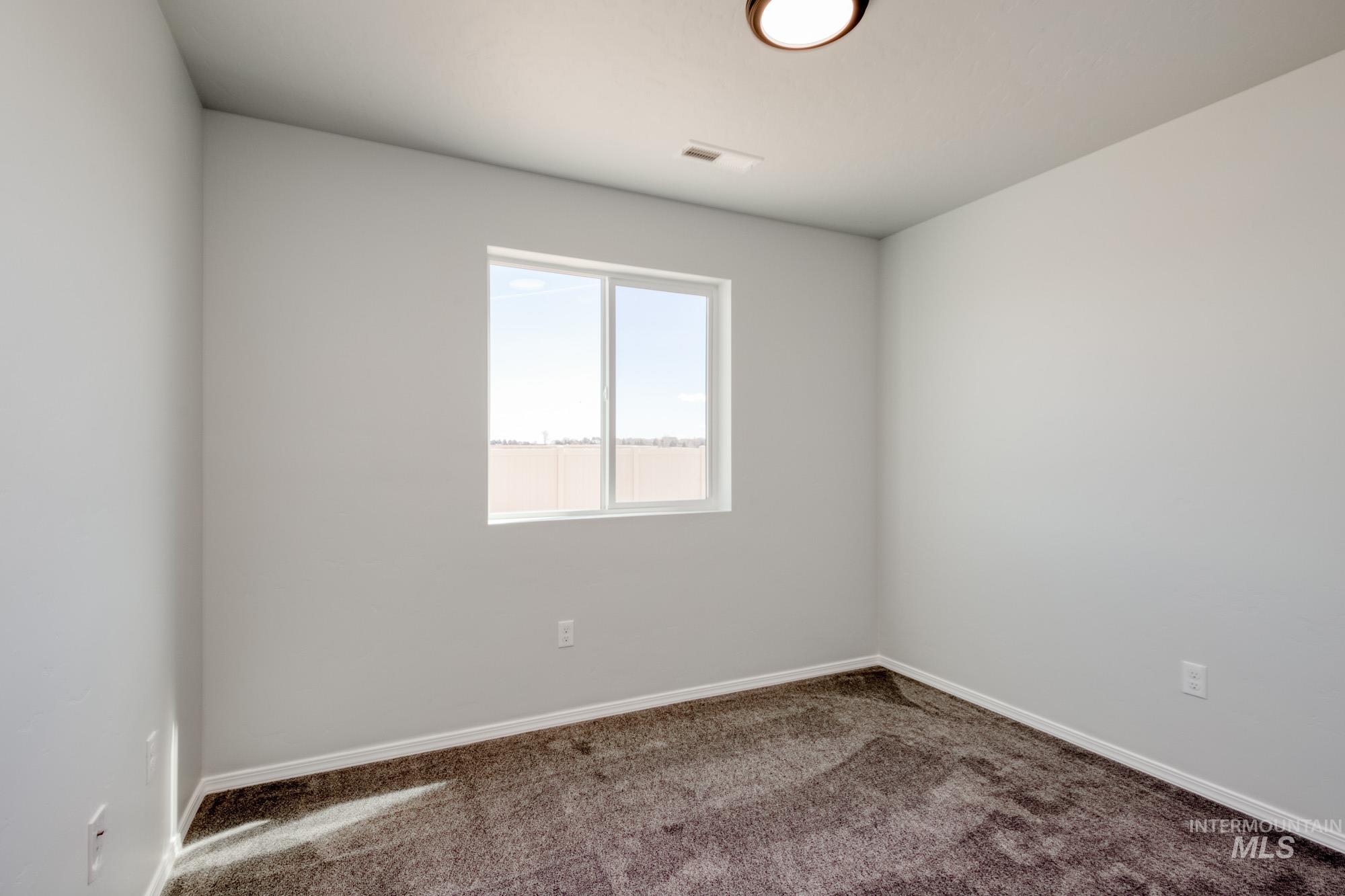 Carpeted empty room with baseboards