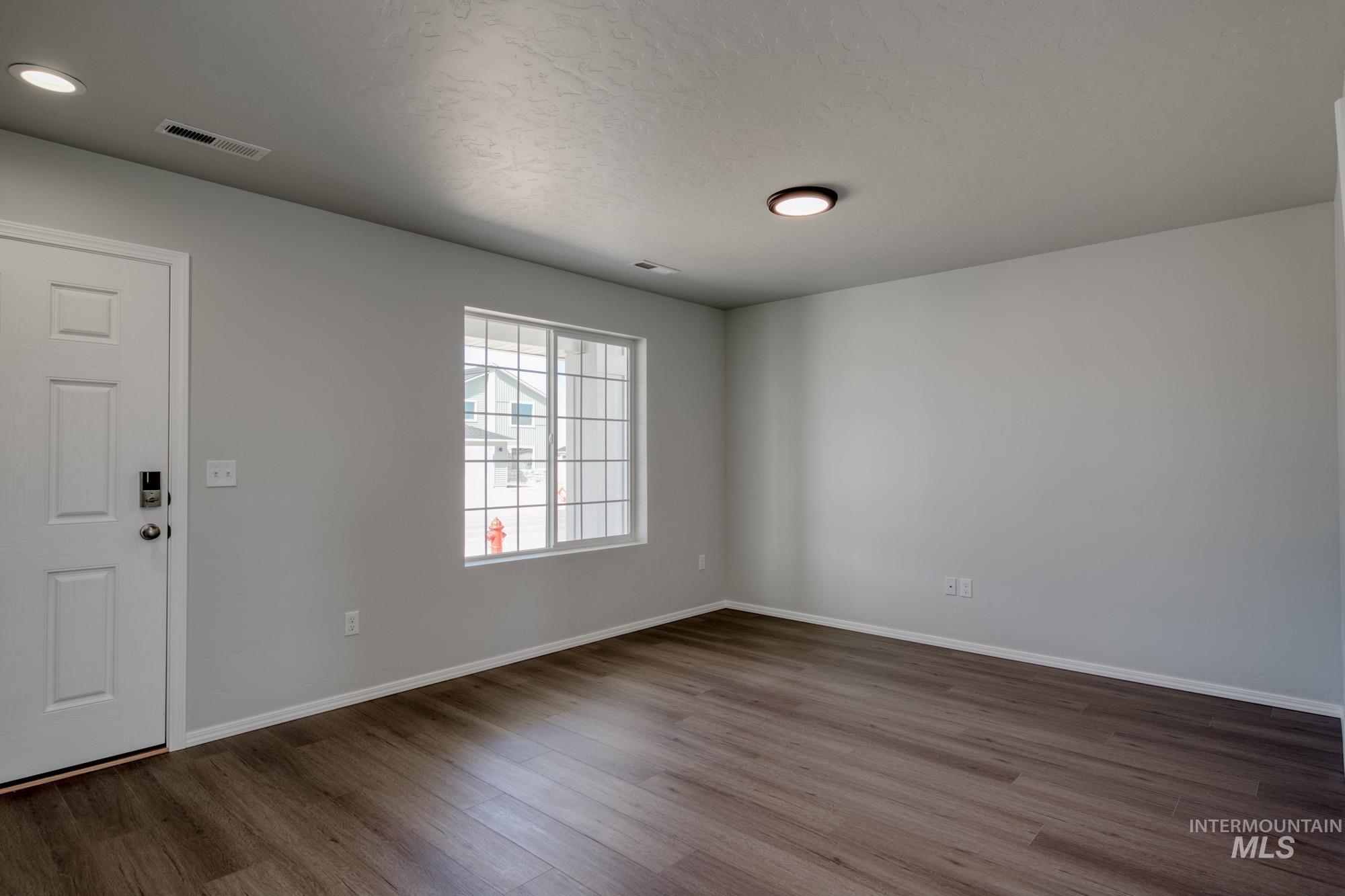 Foyer entrance featuring dark wood-type flooring and a textured ceiling