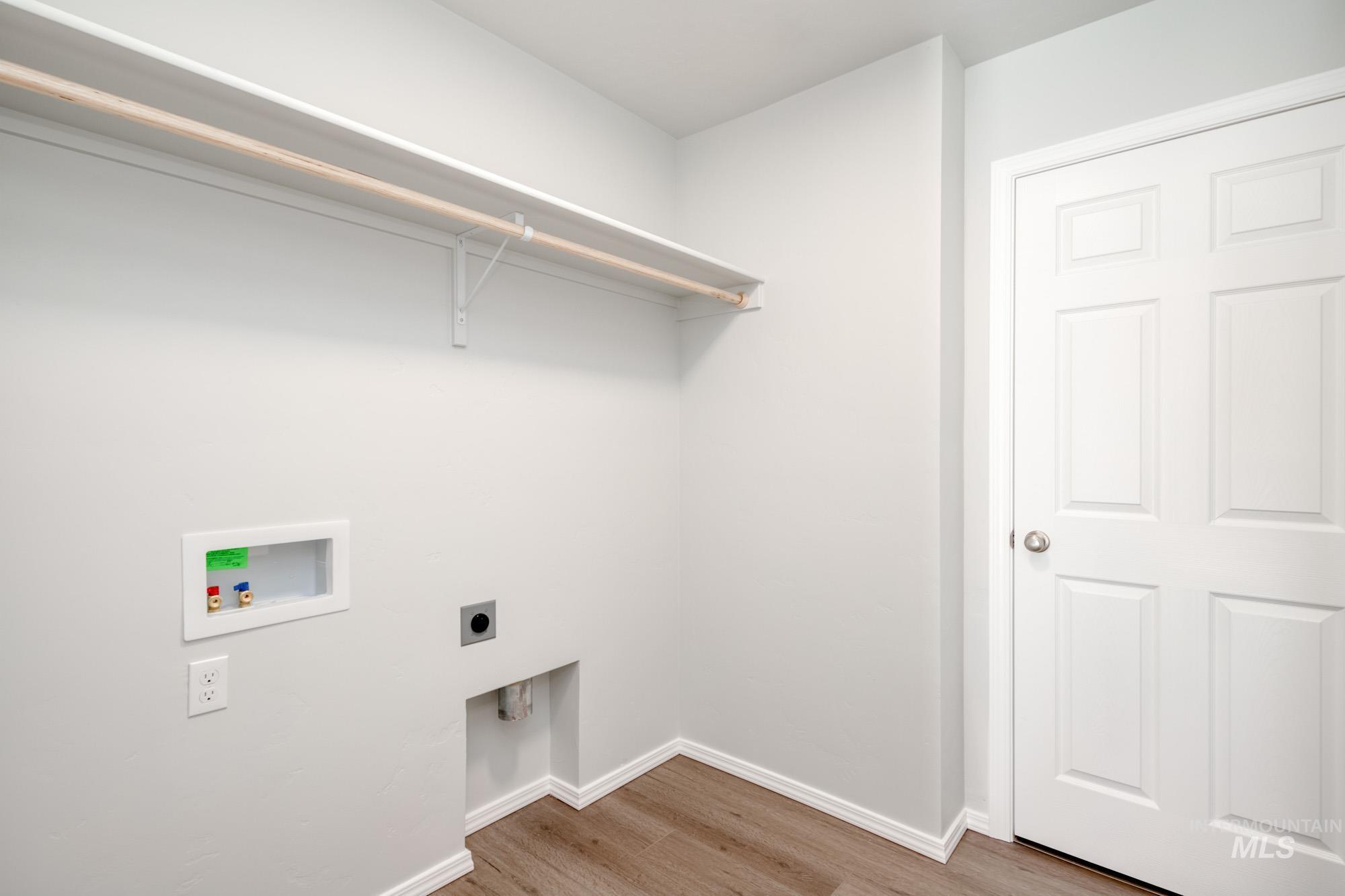 Washroom with light wood-style floors, electric dryer hookup, and hookup for a washing machine