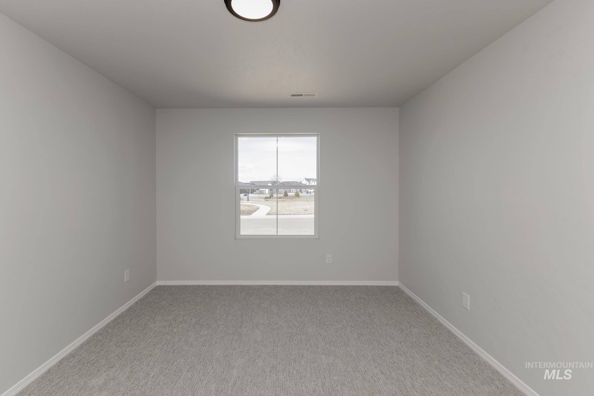 Unfurnished room featuring baseboards and light carpet