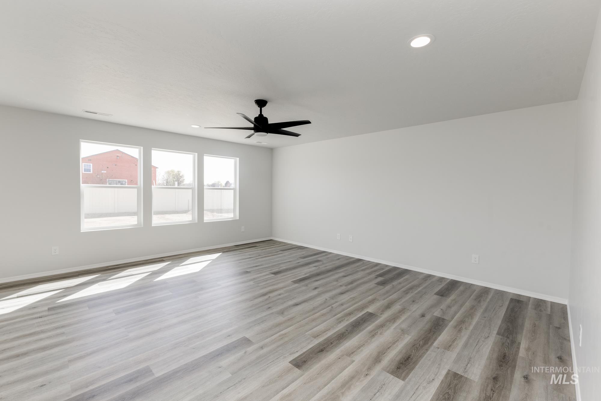 Empty room with light wood-type flooring, recessed lighting, and a ceiling fan