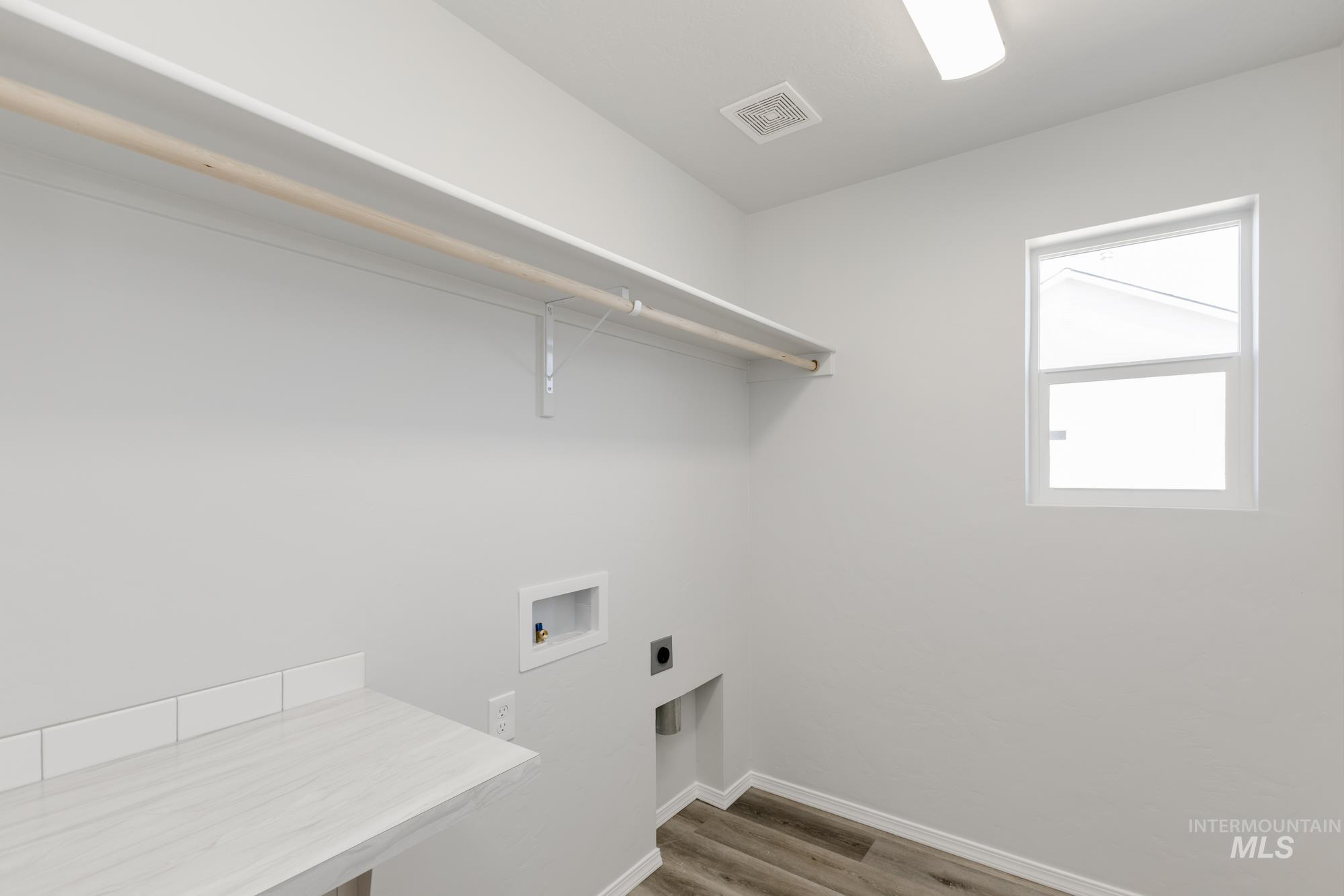 Laundry room featuring light wood-style floors, hookup for a washing machine, and electric dryer hookup