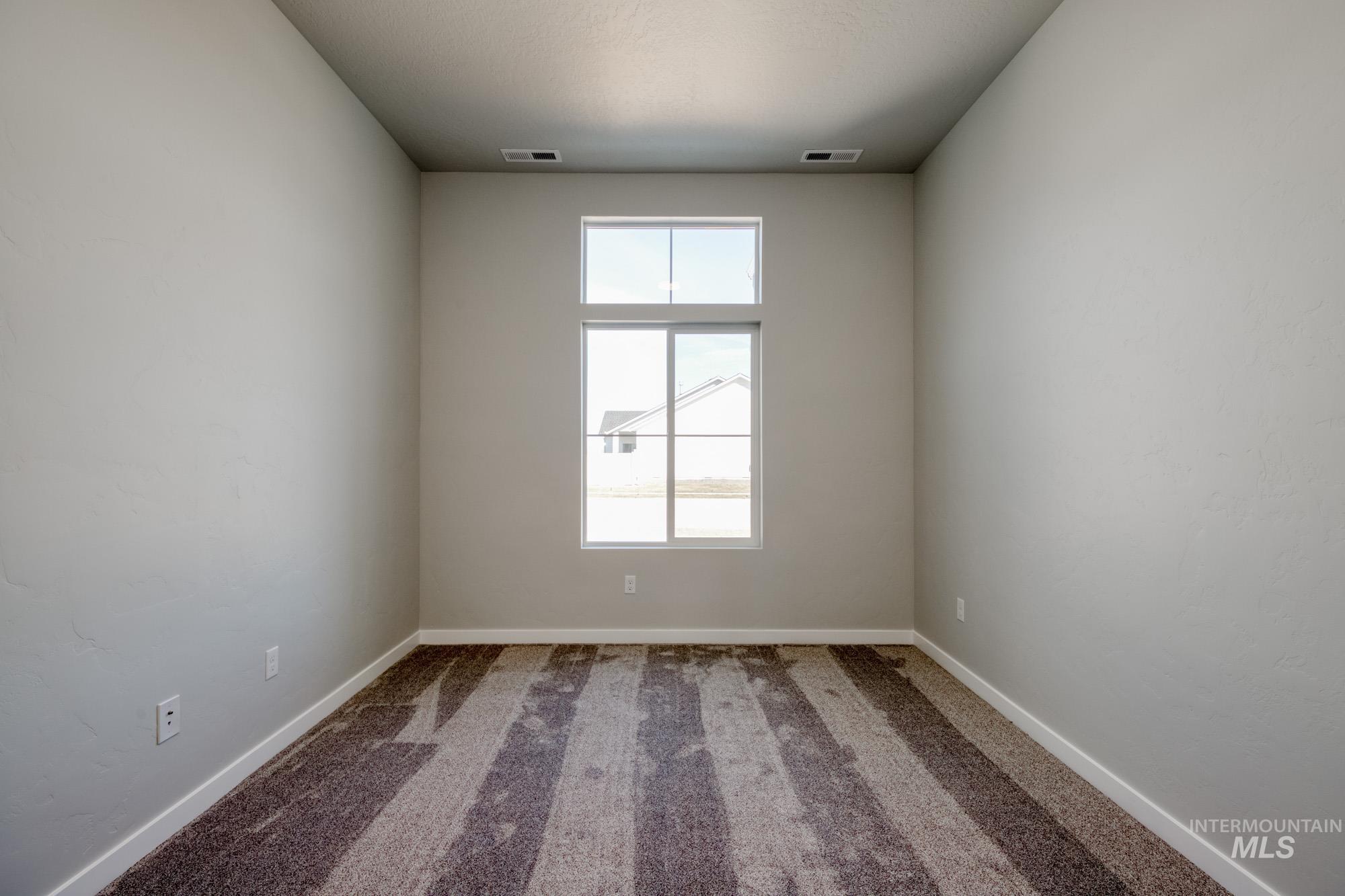 Spare room featuring carpet floors and baseboards