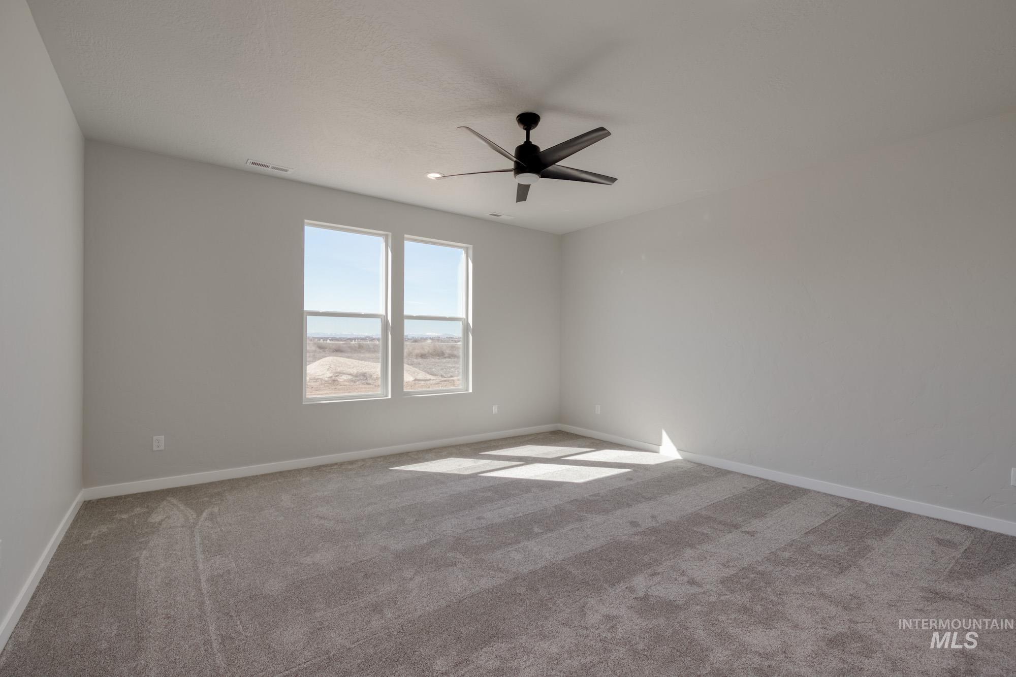 Spare room with light carpet and ceiling fan