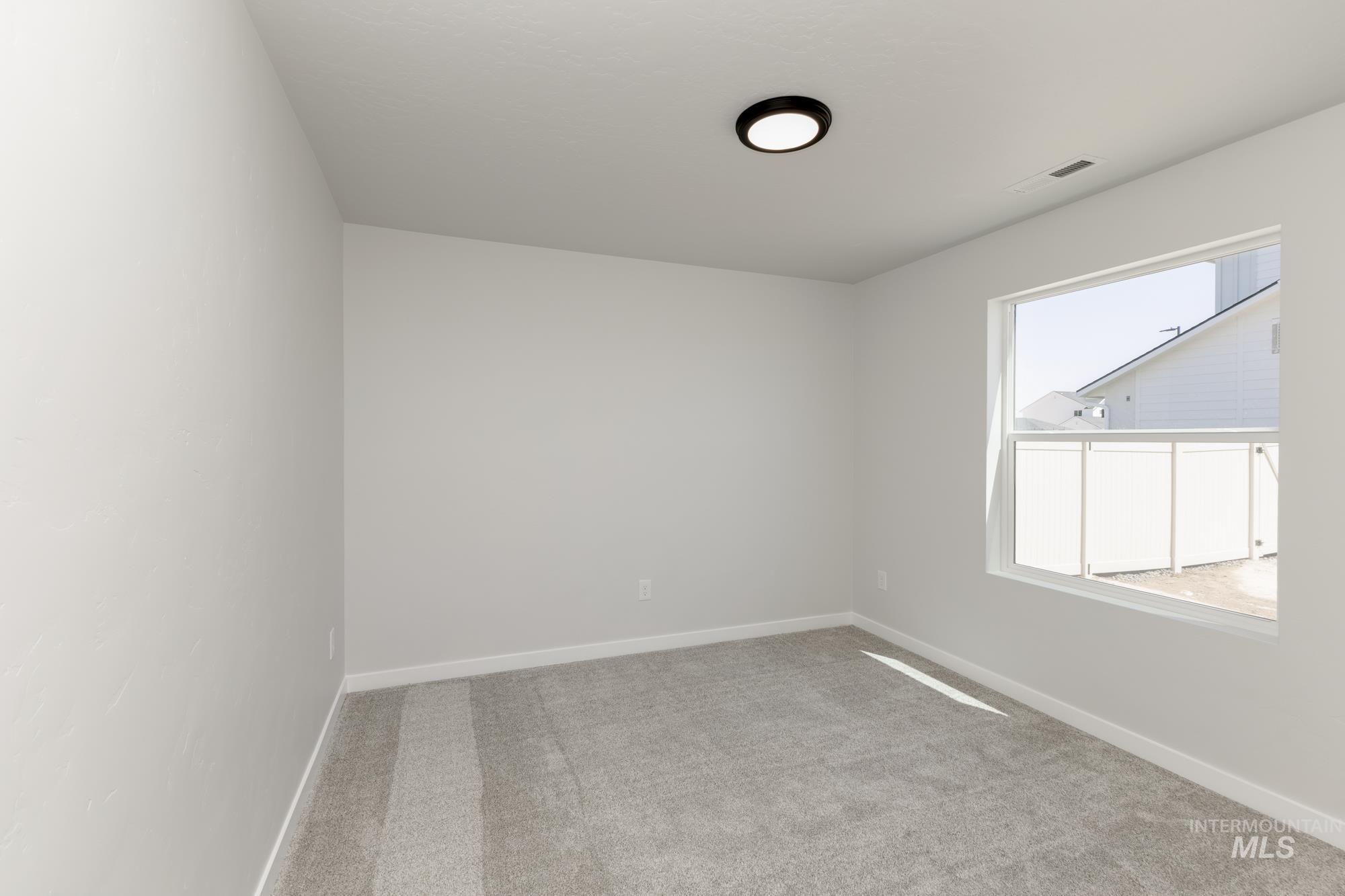 Spare room featuring carpet and baseboards