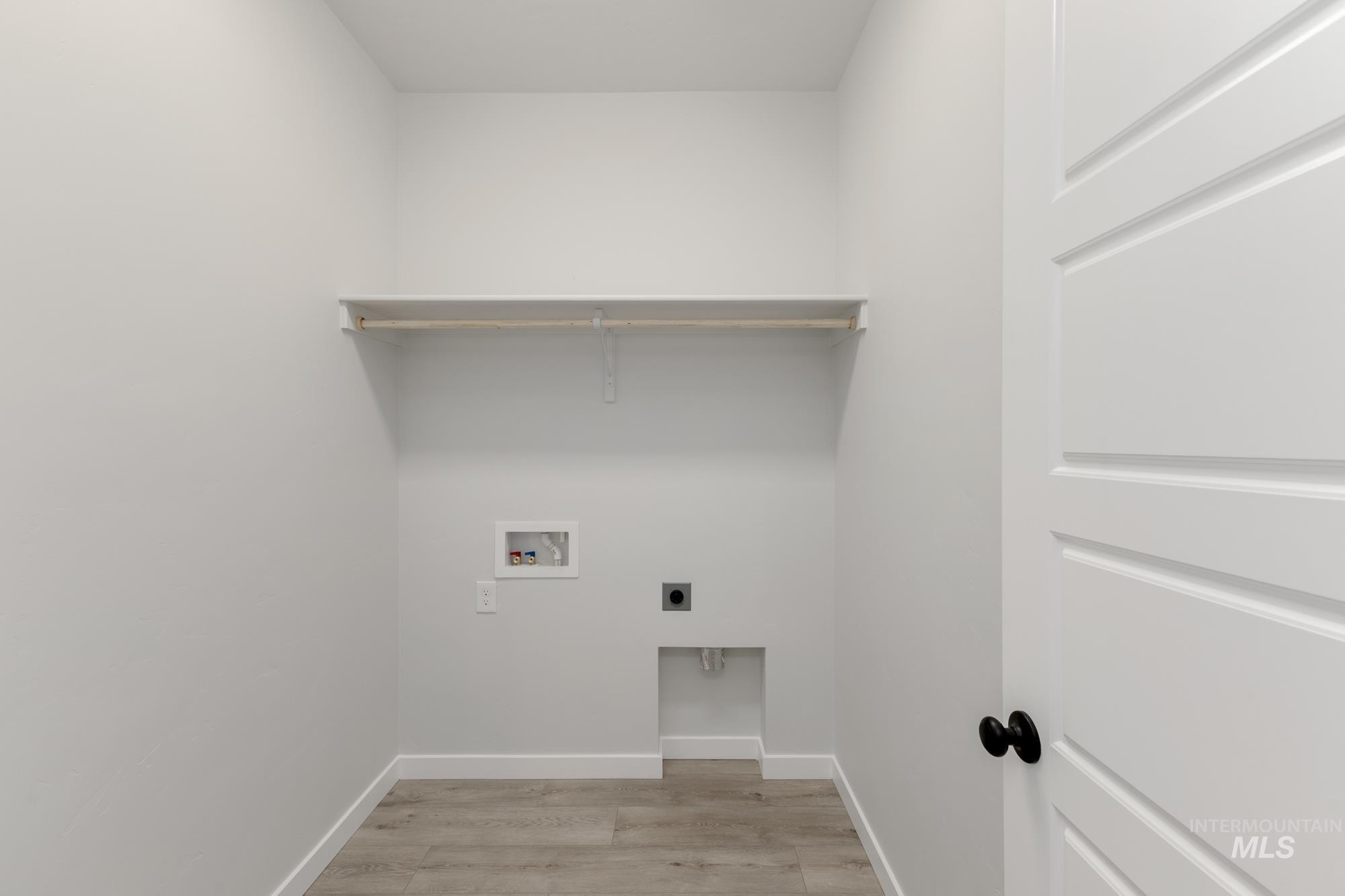 Washroom featuring light wood finished floors, electric dryer hookup, and hookup for a washing machine