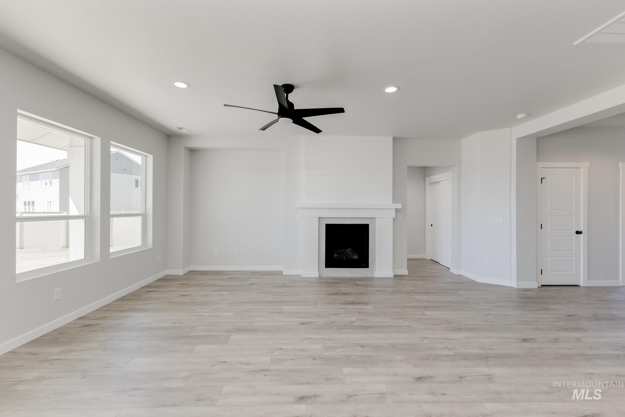 Unfurnished living room featuring recessed lighting, a ceiling fan, light wood-type flooring, and a fireplace